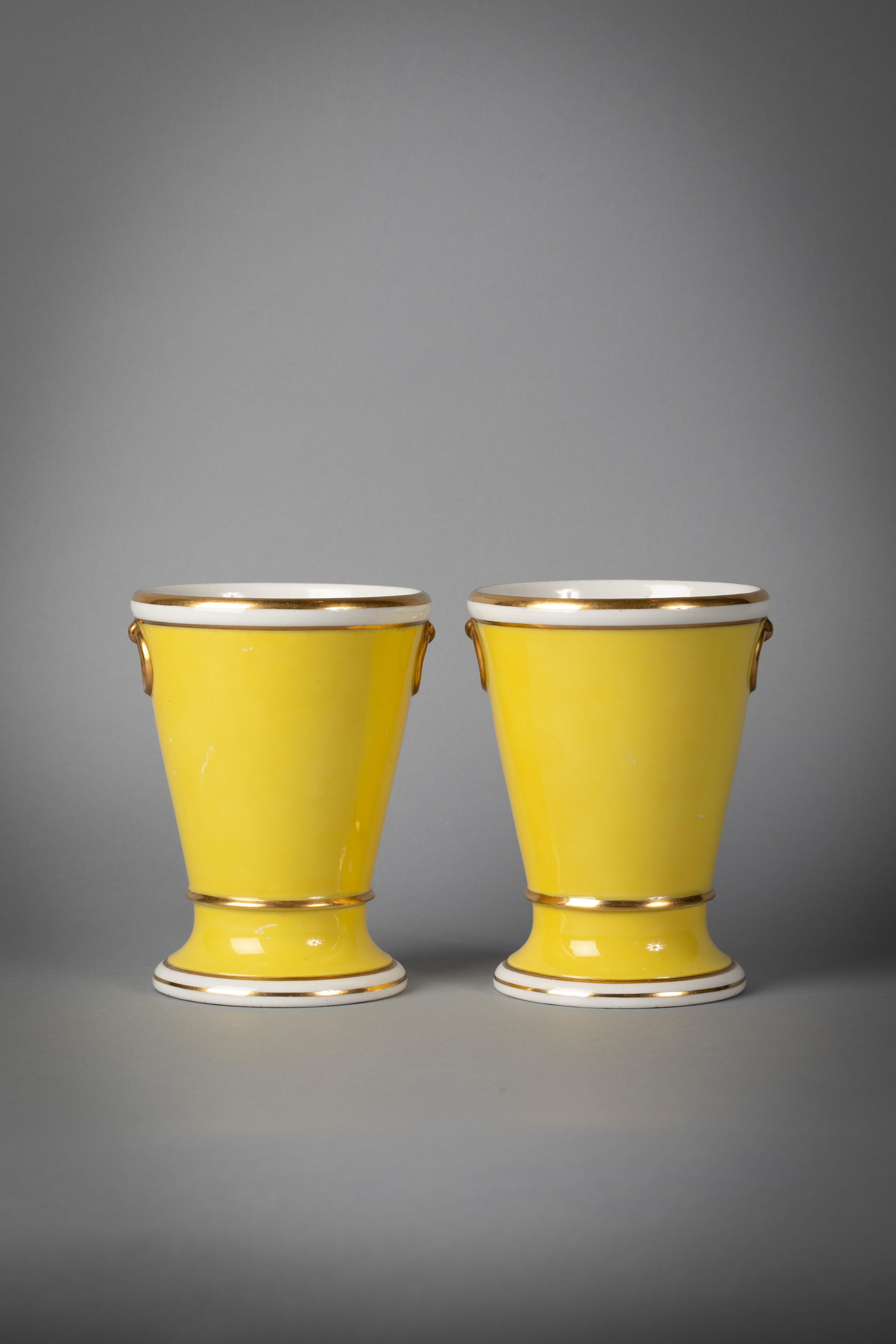 Paar englische Porzellanvasen mit gelbem Grund, Worcester (Flight and Barr), um 1800.

Puderfarbene Schriftzeichen. Bemalt mit einem üppigen Blumenstrauß in einer achteckigen Umrahmung, flankiert von vergoldeten, unechten Ringgriffen.