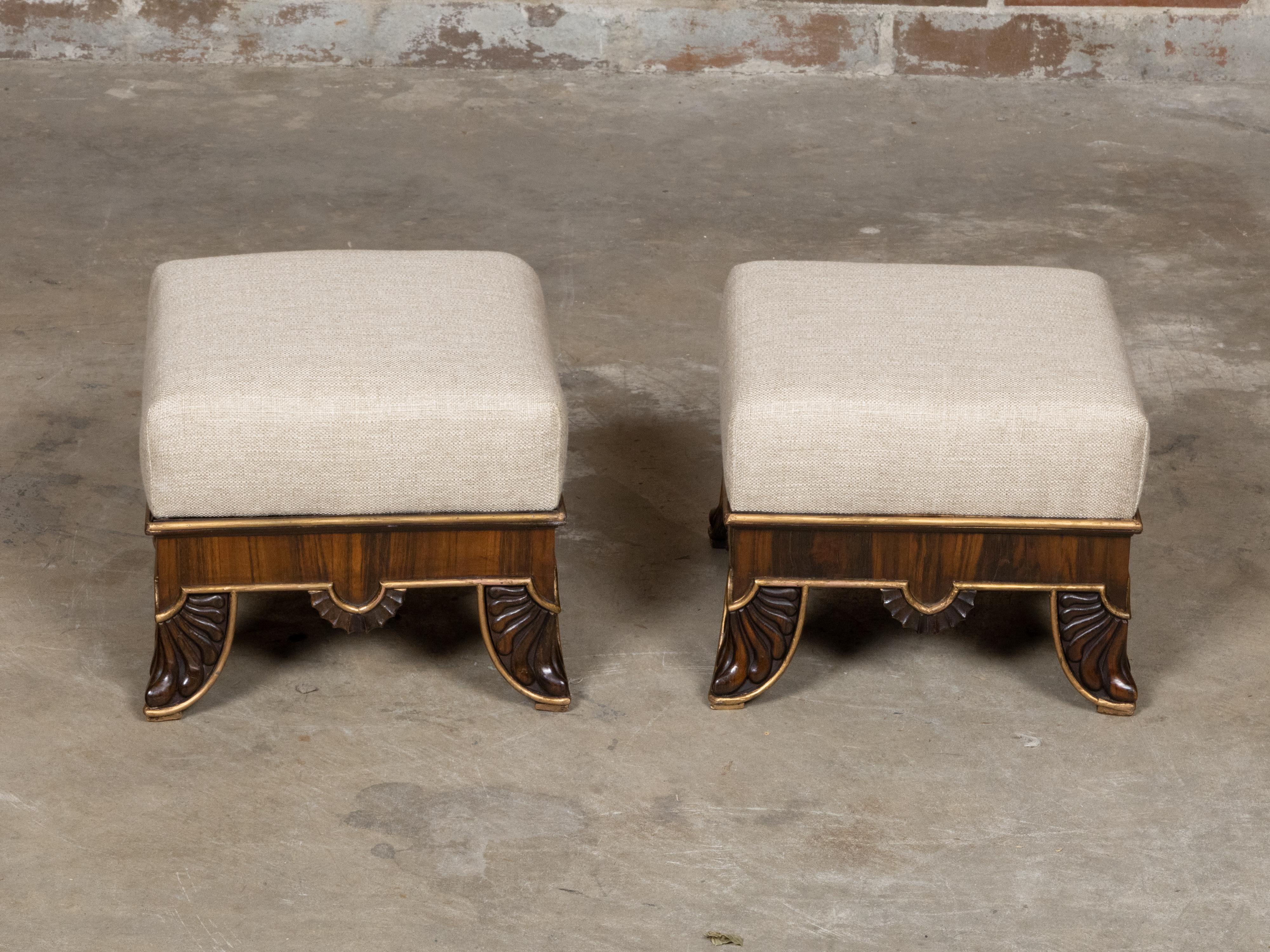 Ein Paar englischer Fußhocker aus der Regency-Periode aus dem 19. Jahrhundert mit geschnitzten Füßen, vergoldeten Akzenten und individueller Polsterung. Dieses exquisite Paar englischer Fußhocker aus der Regency-Periode des 19. Jahrhunderts steht