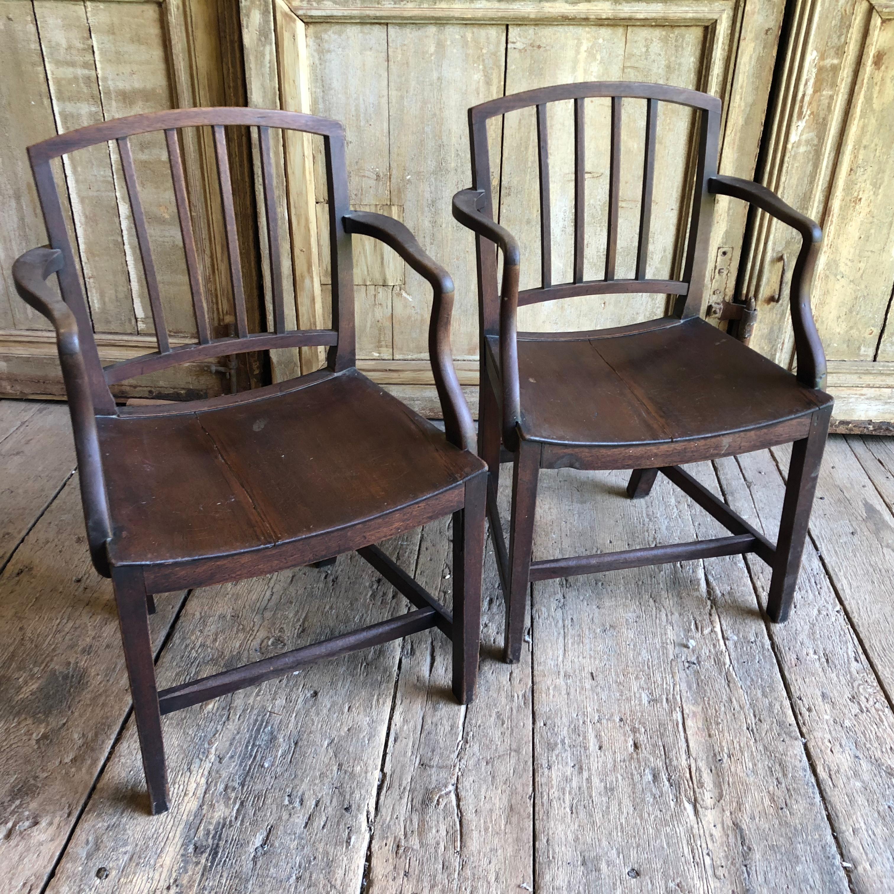A pair of English Regency armchairs in mahogany with salt backs and slightly curved seats and bowed arms, circa 1830.