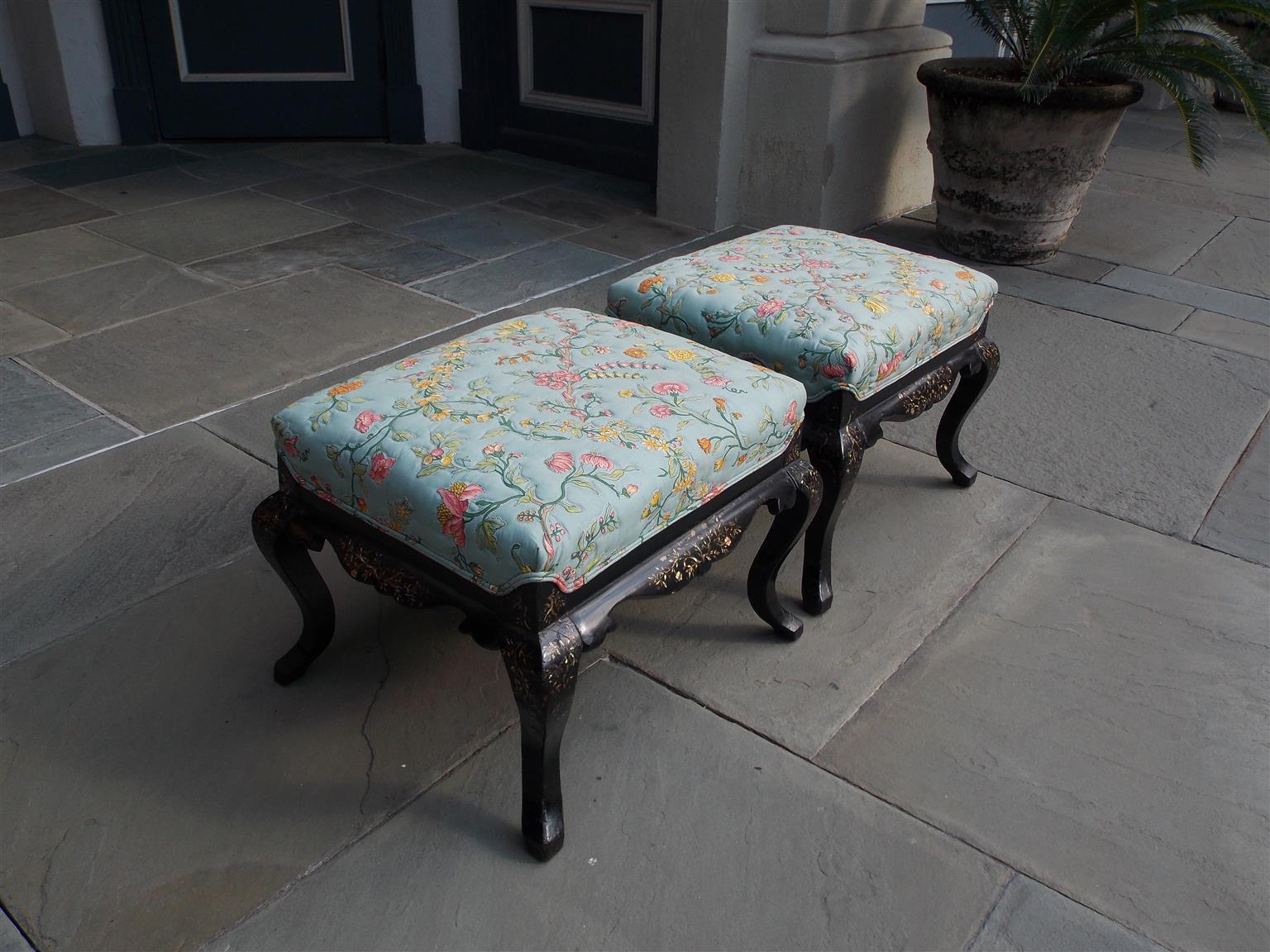 Pair of English Regency black lacquered upholstered stools with mother of pearl inlays, quilted floral upholstery, carved scalloped skirts, and resting on shaped knees with cabriole legs, Early 19th century.