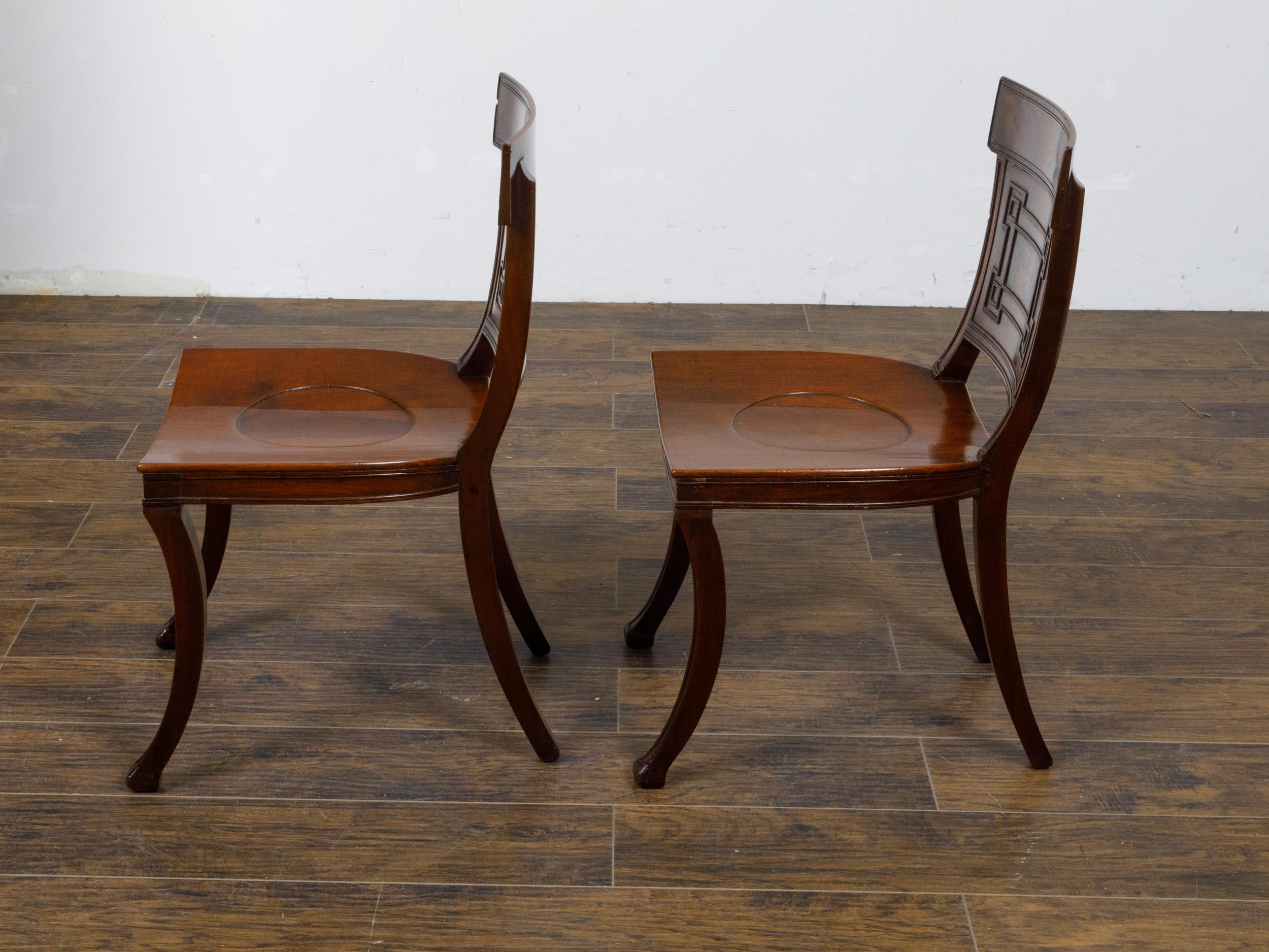 Carved Pair of English Regency Mahogany Hall Chairs with Painted Coat of Arms For Sale