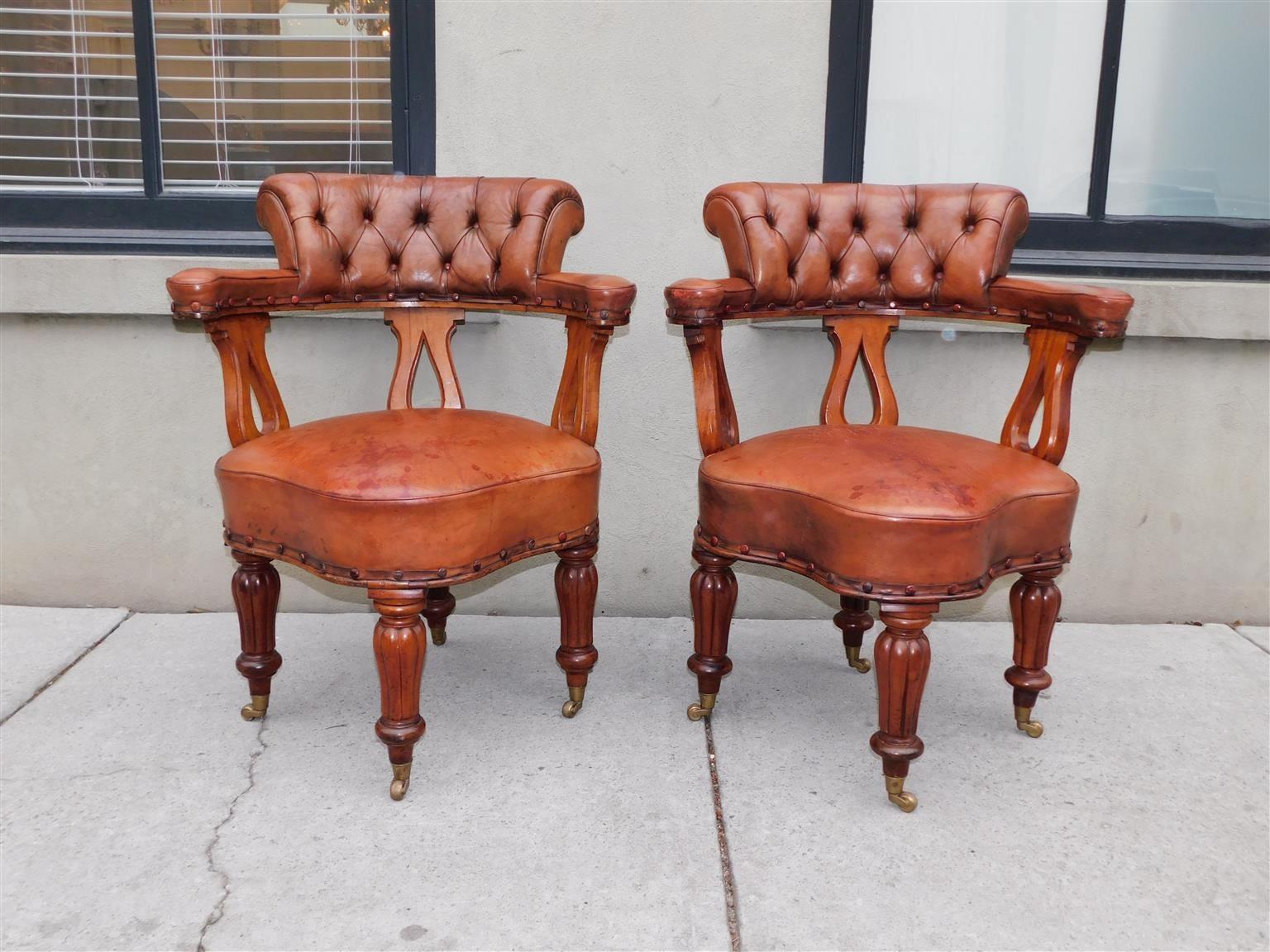 Coppia di poltroncine inglesi Regency in mogano con schienale a lira, sedute in pelle con cuciture a curvatura e poggianti su gambe scanalate e scanalate a bulbo con rotelle originali in ottone, inizio del XIX secolo.
