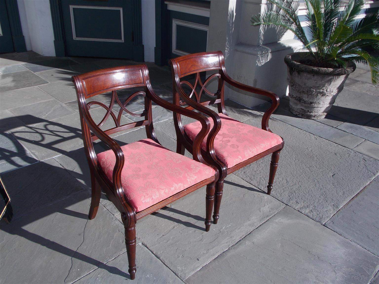 Pair of English Regency mahogany upholstered seat armchairs with carved reeded diamond form splat backs, foliate medallions, incised scrolled arms, and resting on turned bulbous frontal legs with splayed rear legs, Early 19th century.