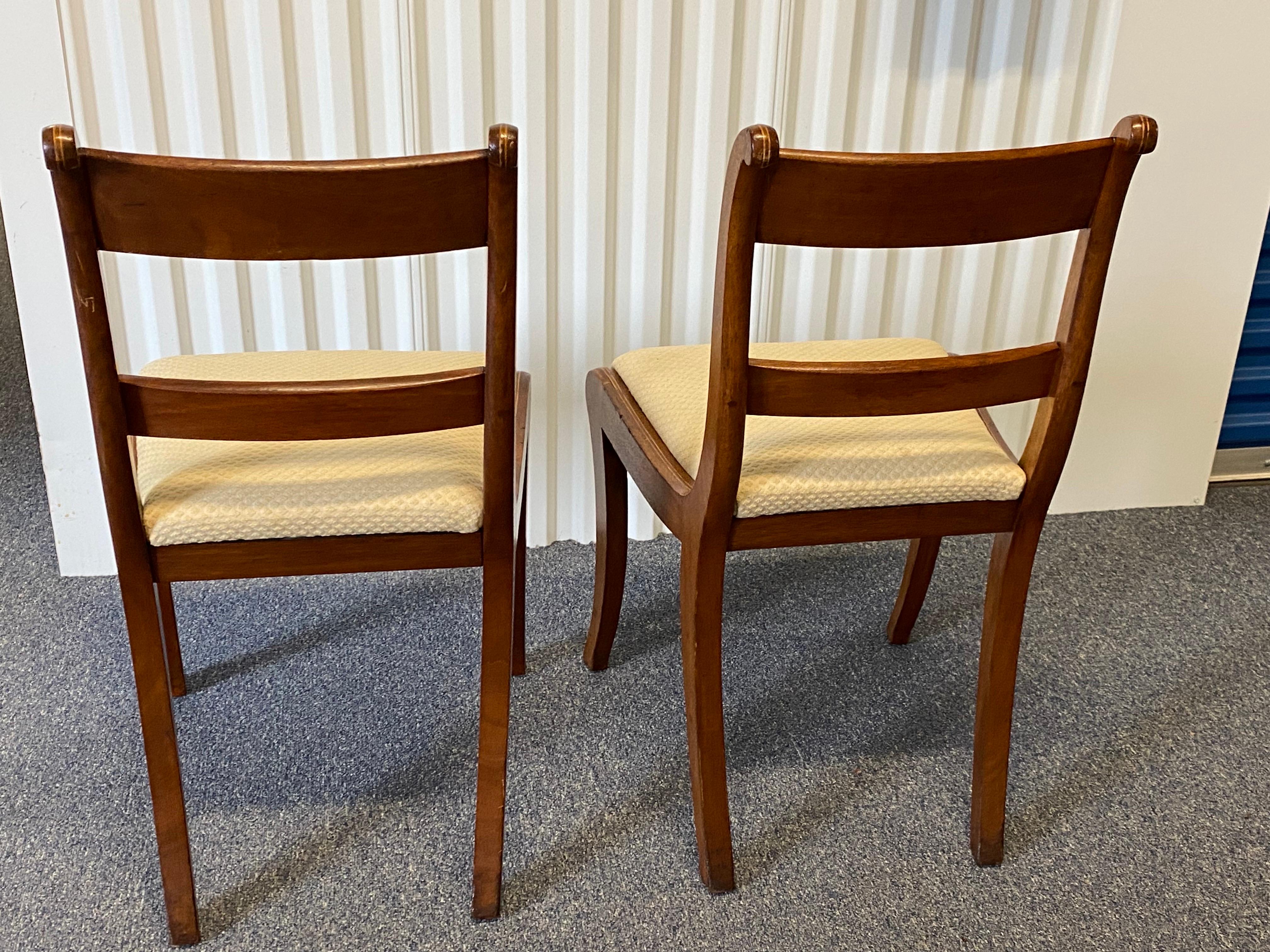 Coppia di sedie laterali inglesi Regency in mogano con intarsi, inizio XIX secolo.
Sono caratterizzate da gambe a sciabola dolcemente ricurve e strombate, uno schienale rettangolare con binari a cresta ricurva che terminano con piani a volute,