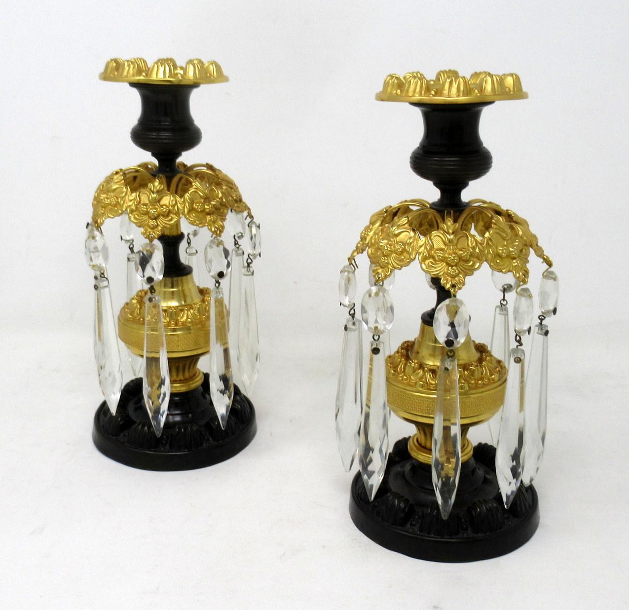A stylish pair of English regency period patinated bronze and ormolu weighted table or mantle single light lustres of superb craftsmanship and quality. First quarter of the nineteenth century.

Each candlestick with bronze reeded sconce above