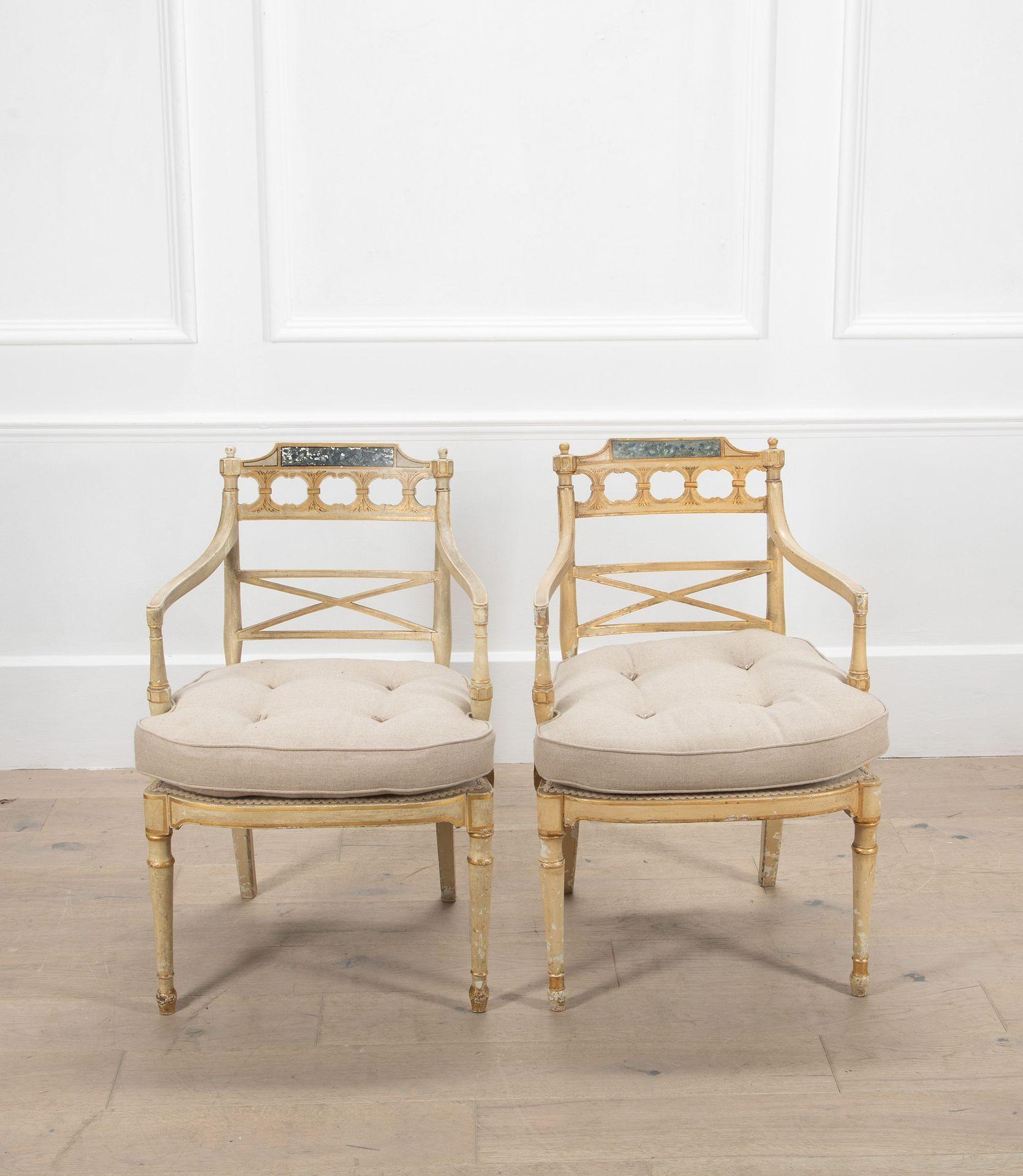 Pareja de sillones ingleses de la Regencia con pintura original y remates decorativos.

Con señales de pintura posterior en la pata trasera de uno. Las sillas habrían sido originalmente de caña, pero se han retapizado con cojines.