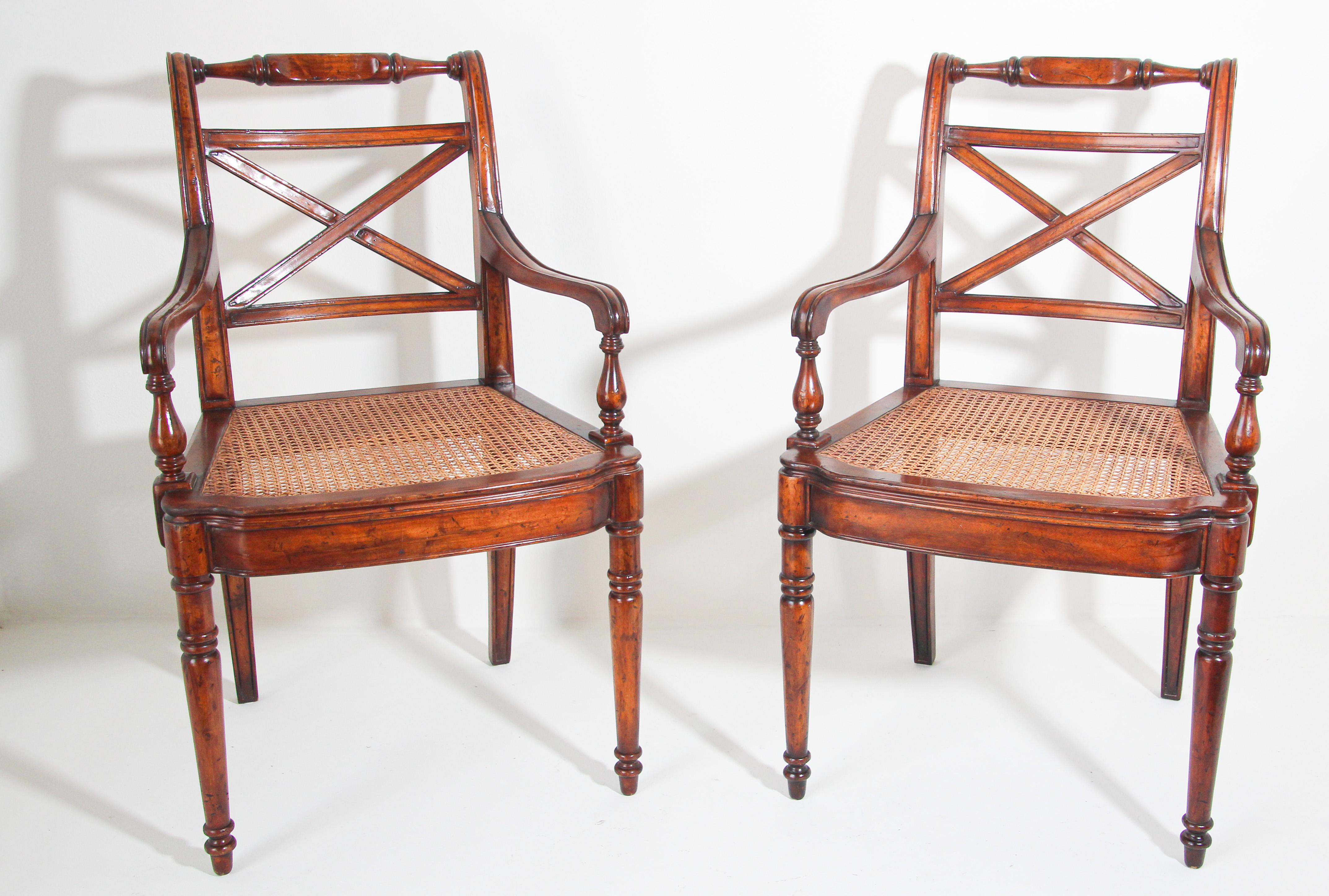 Pair of 20th century English Regency style library armchairs with X-shaped back, turned top rails and arms, and cane seats.
Pair of elegant classic armchairs with rounded arms raised on carved feet, solid wood construction, distressed antique