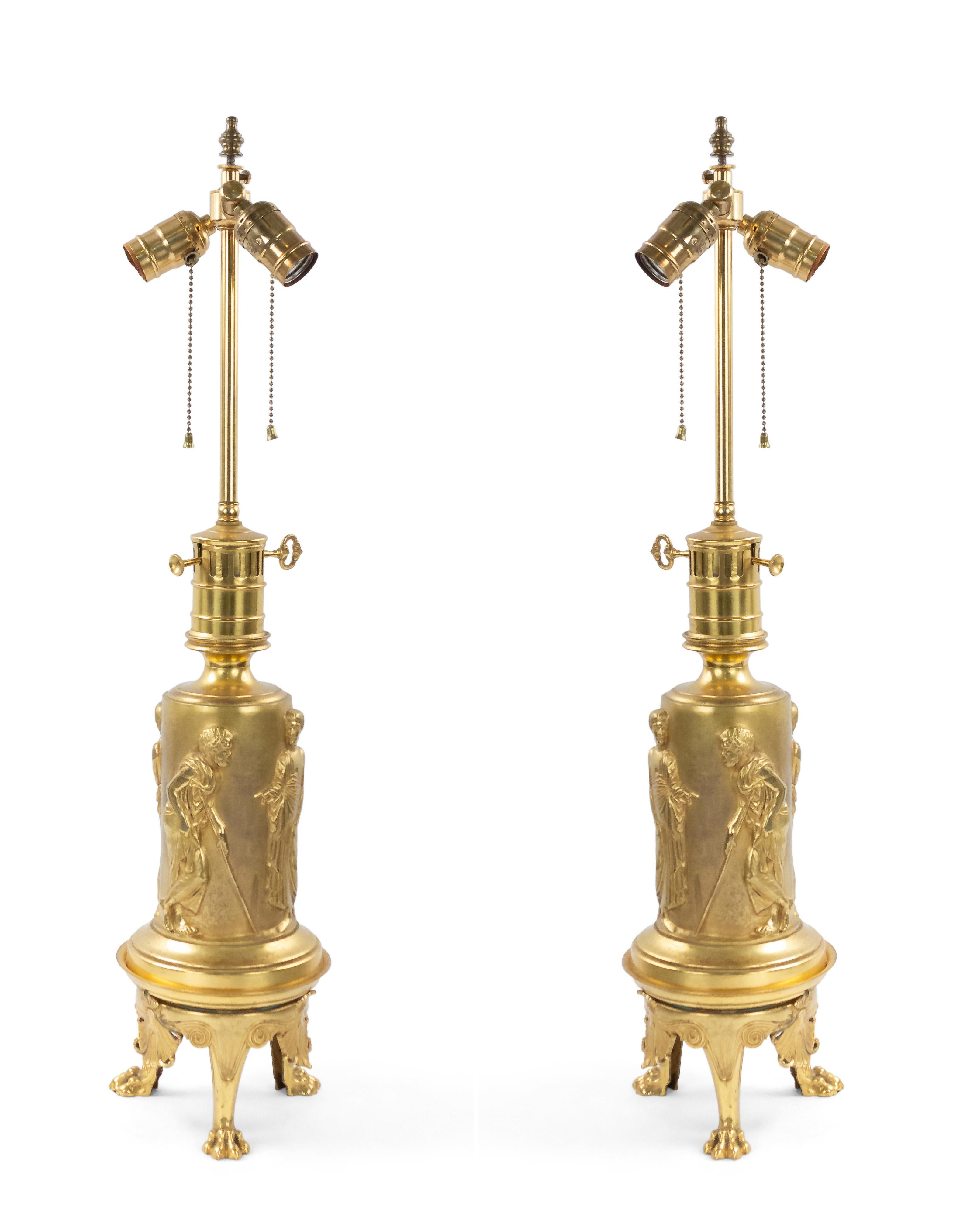 Paire de lampes de table en bronze doré de style Regency anglais (19e siècle), à l'origine pour l'huile, avec des figures classiques en relief sur une base à 3 pieds (VENDU COMME Paire).

