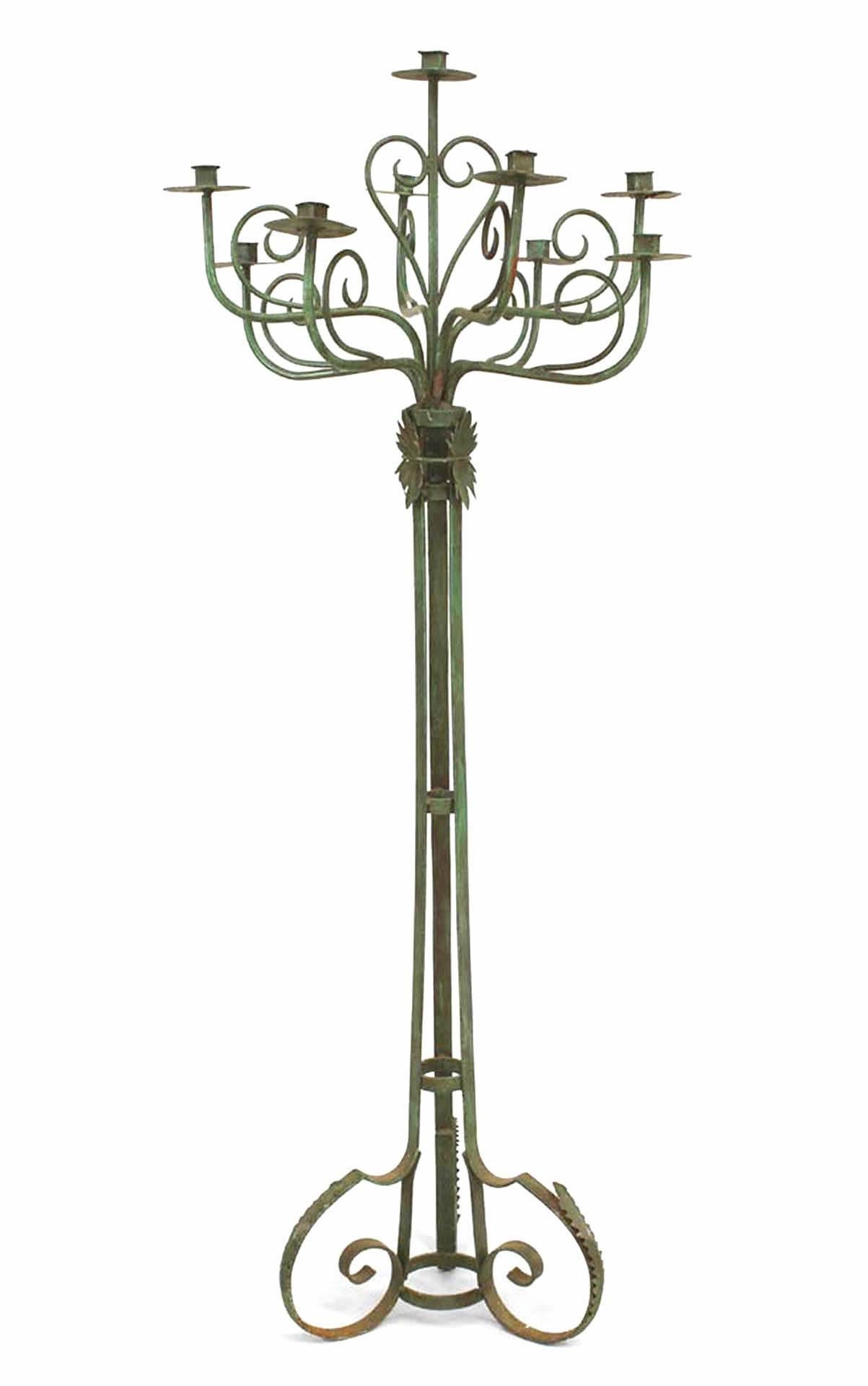 Paire de torchères de sol en fer forgé de style Renaissance anglaise (19/20e siècle), patinées en vert, avec 10 bras en forme de volutes sur une base à triple volute (vendu par paire).

