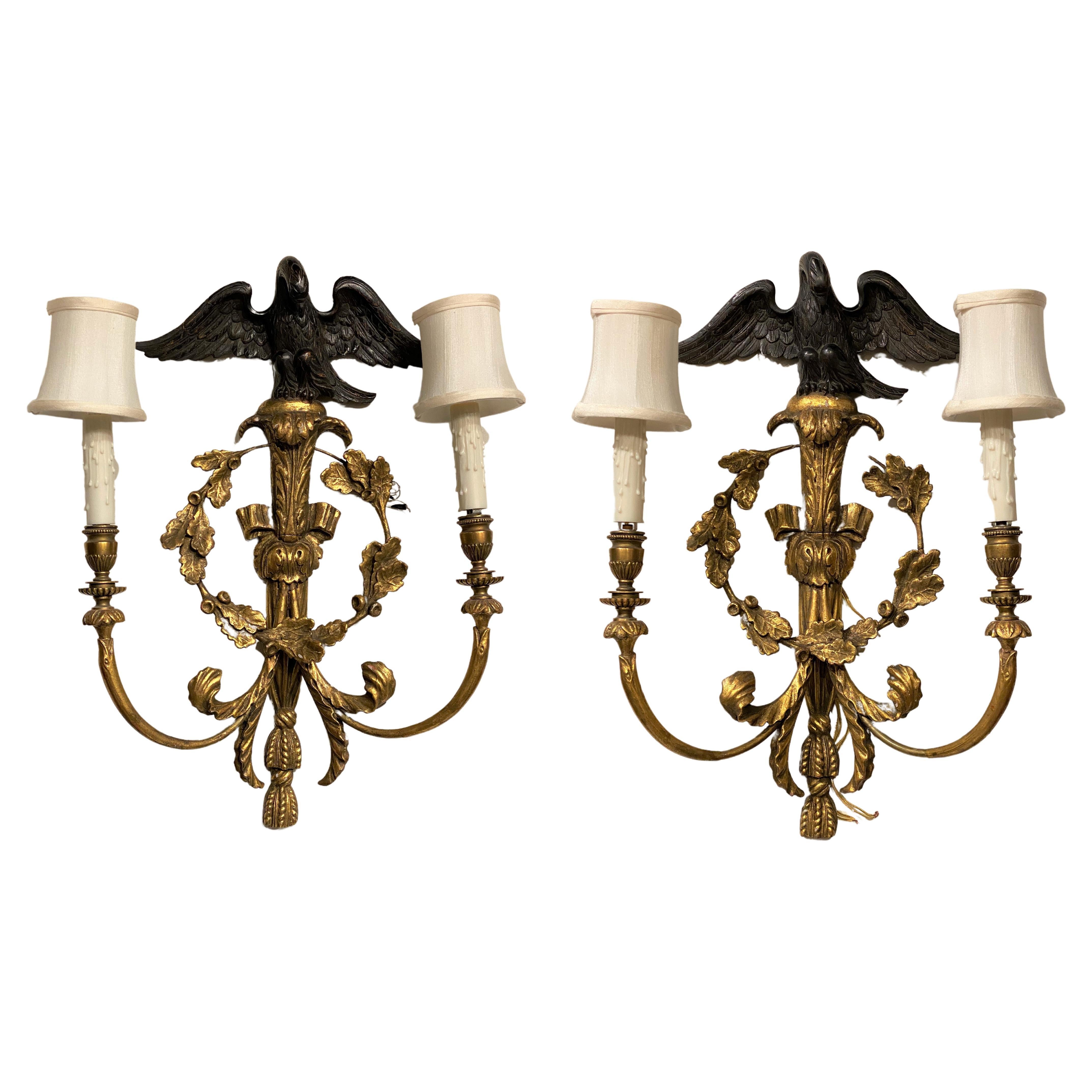 Paire d'appliques à deux lumières de style rococo anglais en bois doré avec dessus en forme d'aigle ébénisé en vente