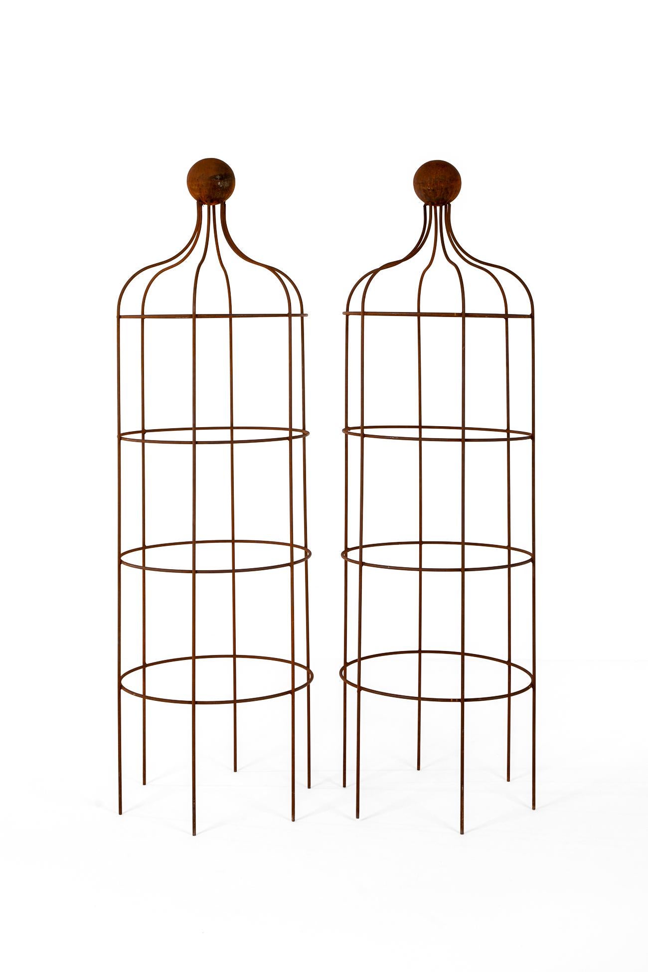 A commanding pair of hand forged wrought iron garden obelisk.

Cylindrical in form with with the top having a curved outline with a ball finial.

This pair was salvaged from the rose gardens from  a north Yorkshire estate.

Price is for the