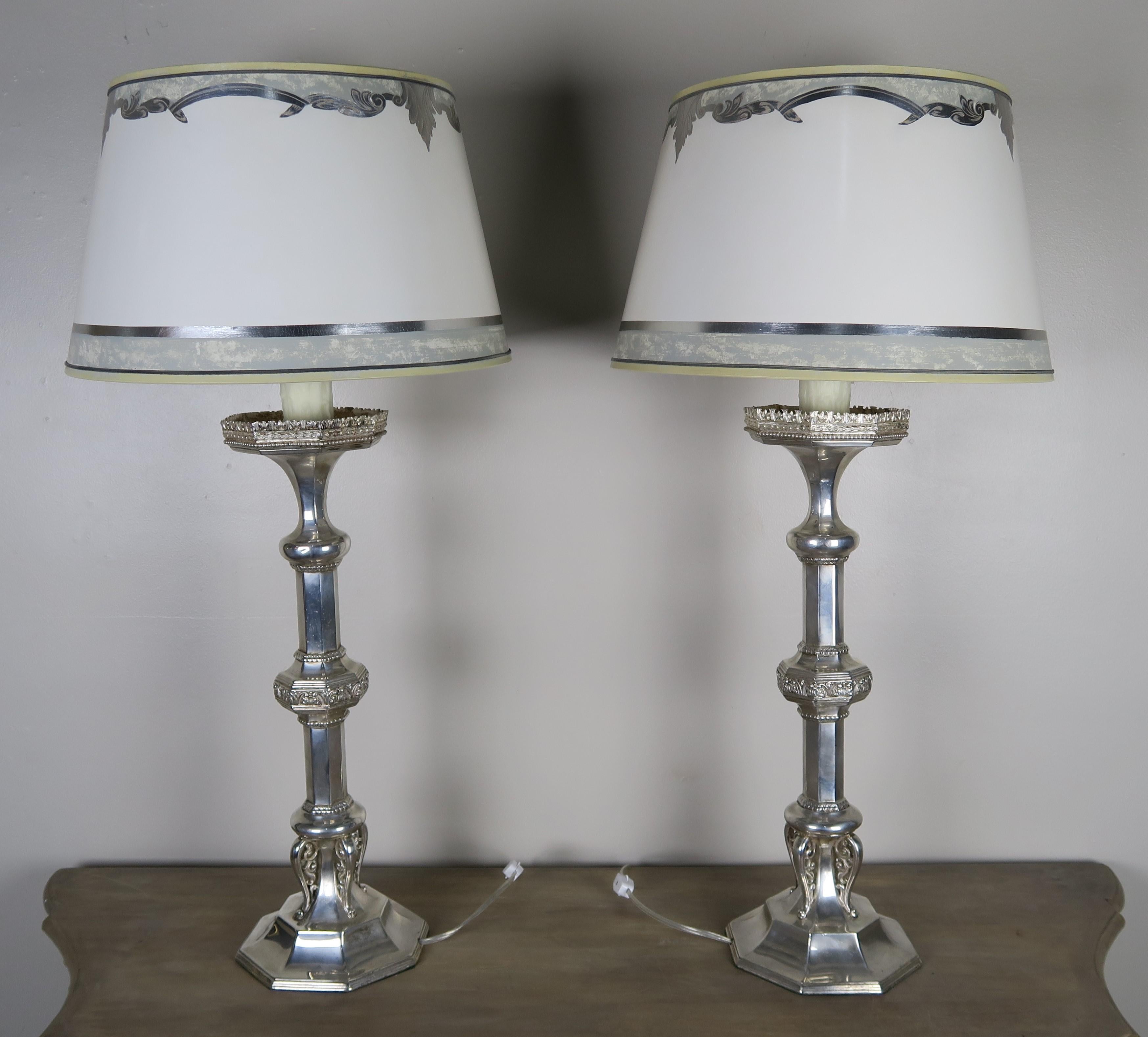 Pair of English Sheffield silver plated lamps with custom hand painted parchment shades. The handwork is beautiful including beading and intricate detailing throughout. The candlesticks stand on octagonal bases that mimicks the octagonal bobeches.