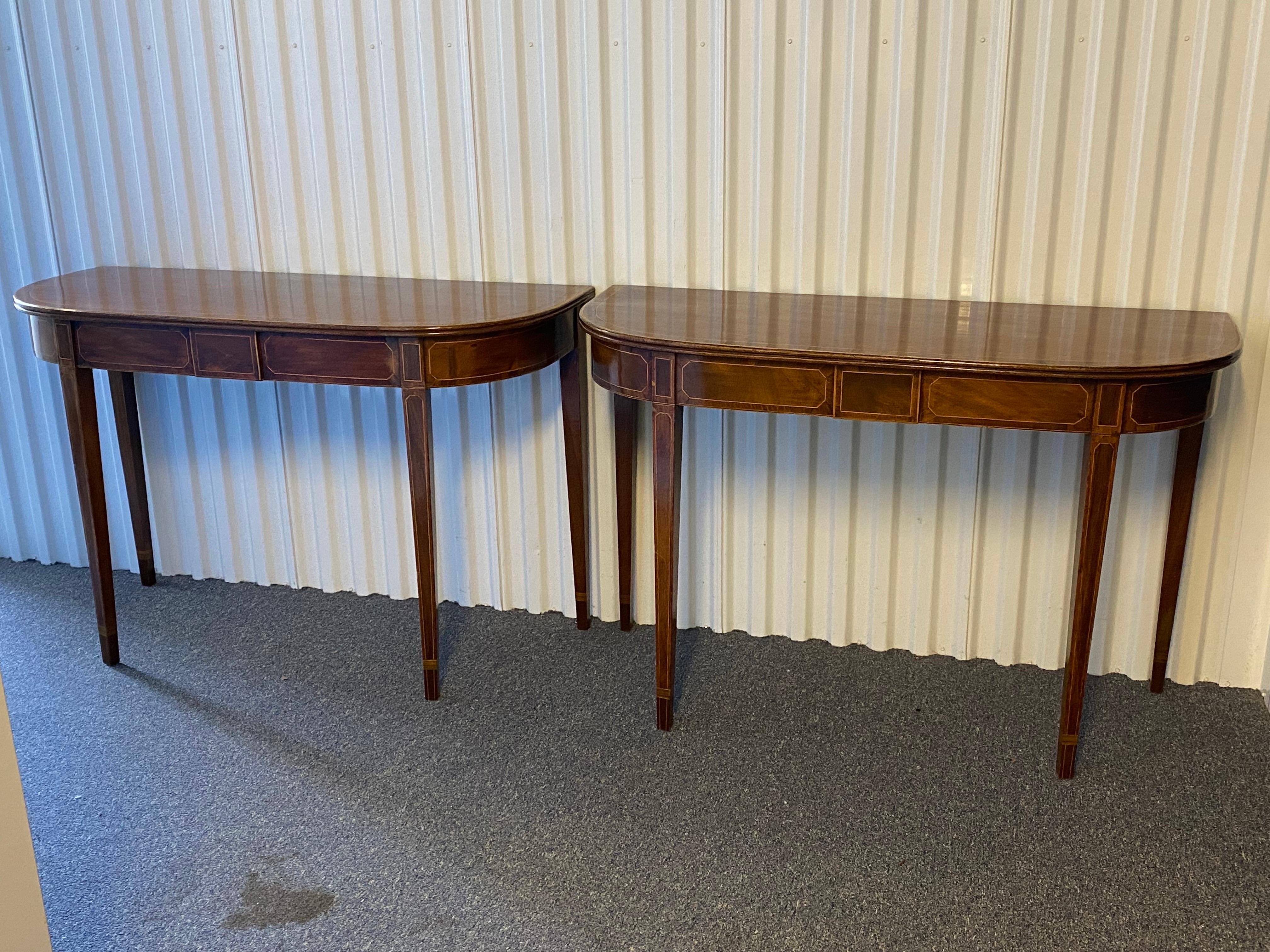 Paire de tables d'appoint en forme de D en acajou de la période Sheraton, c. 1790
En acajou avec cordes et baguettes en bois plus clair, frise incrustée sur le devant, reposant sur quatre pieds en collerette incrustés conformes et