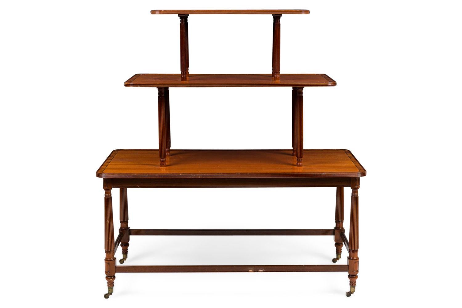PAIR of English Sheraton style buffet / center tables with 3 tiers separated by turned and fluted column supports and ending with brass casters at the base (PRICED AS PAIR)

Some minor wear throughout due to age and use