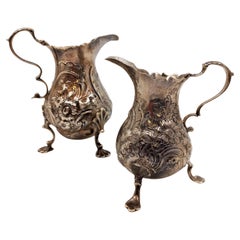 Antique Pair of English Silver Georgian Cream Pitchers on Shell Legs with Floral Pattern
