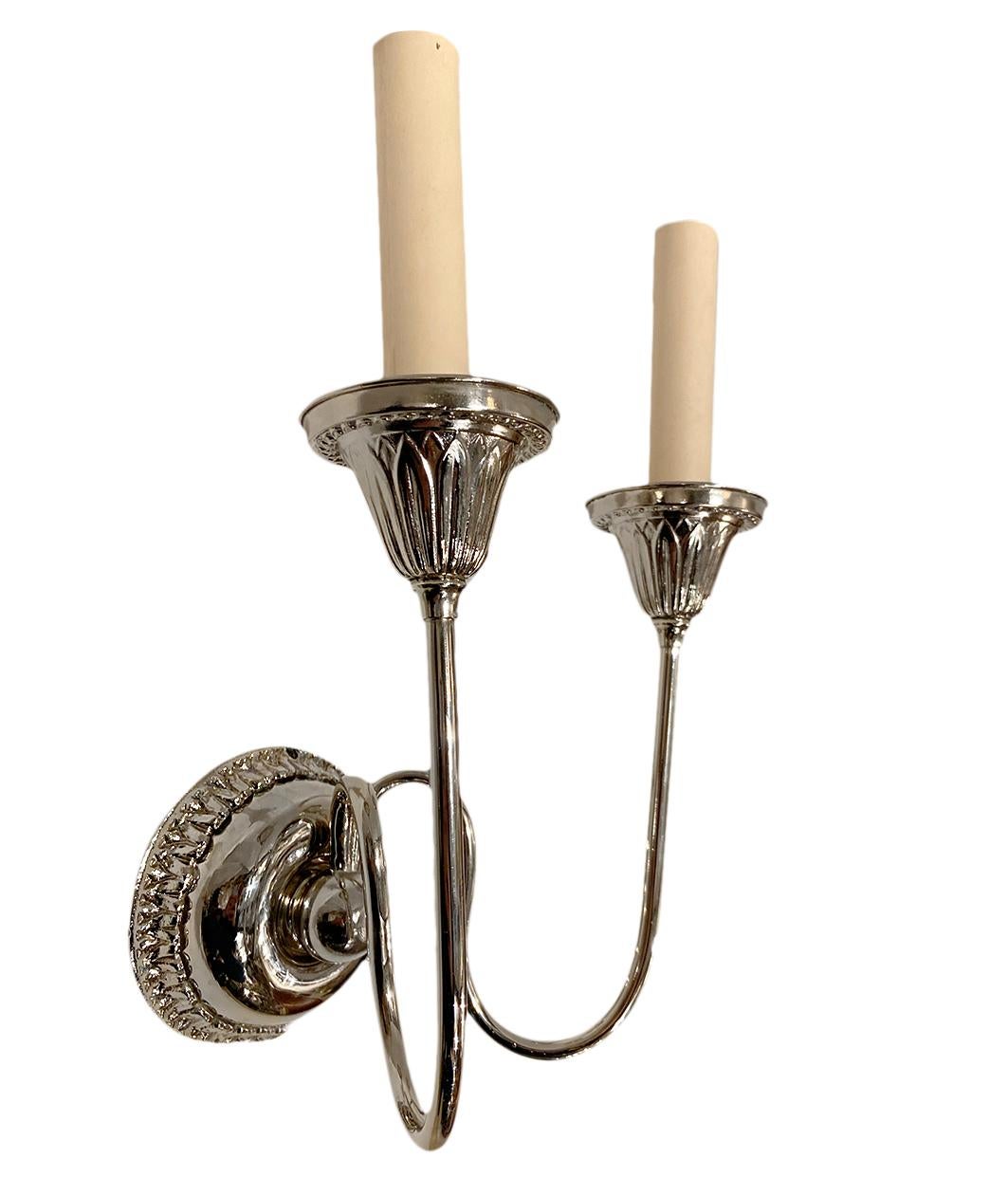 Pair of circa 1920s English neoclassic style silver plated two-arm sconces.

Measurements:
Height 11.5