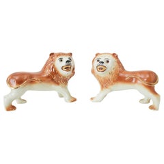 Paire de lions anglais en porcelaine Staffordshire sur pied