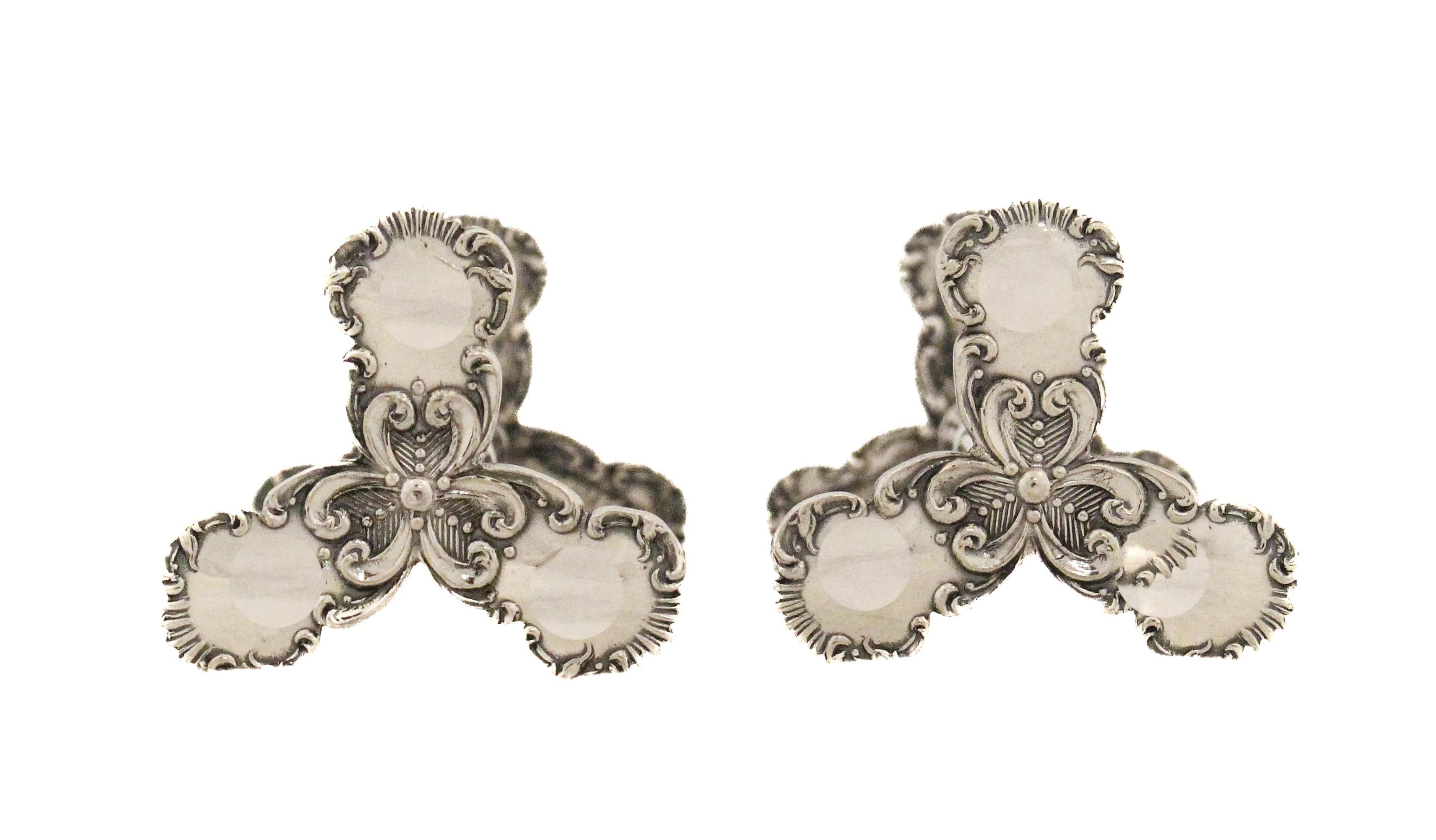 This ornate pair of sterling silver knife rests was made in Sheffield, England, and is fully hallmarked for the year 1837. The maker is Harry Wigfull of the esteemed firm Lee & Wigfull. Each rest features finely detailed repoussé work with elaborate