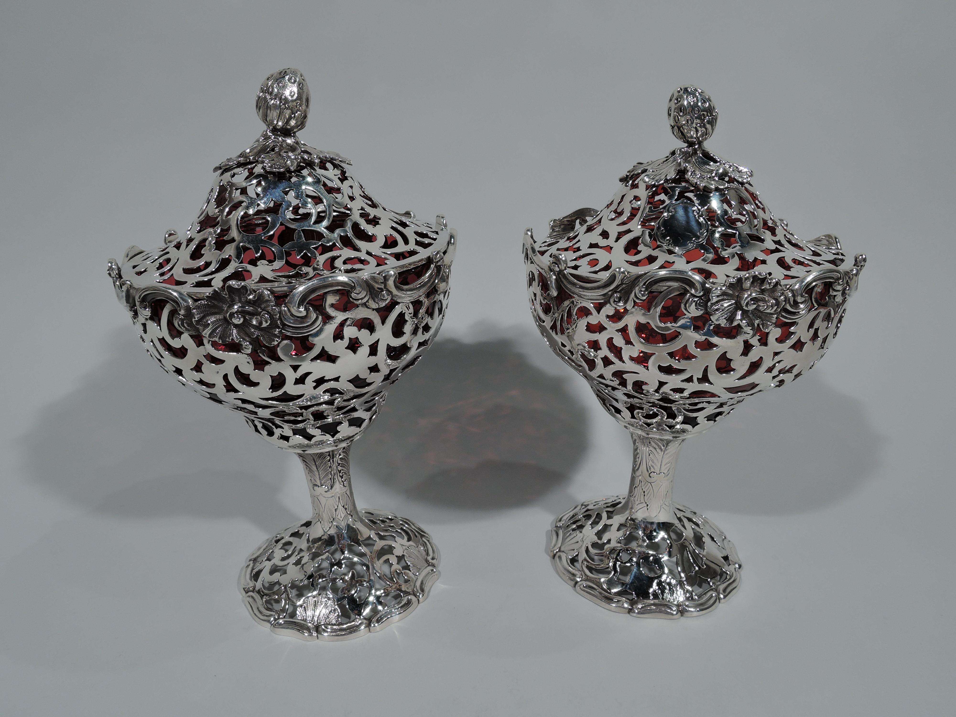 Air of beautiful sterling silver jam compotes. Made by Joseph & John Angell in London in 1845-1848. Each: Shaped oval bowl on solid stem terminating in domed foot. Domed cover with solid leaf-mounted strawberry finial. All-over pierced scrollwork.