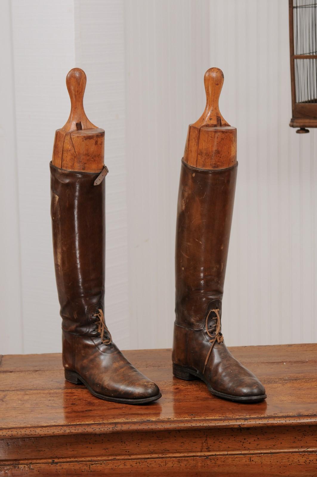 A pair of English Victorian period leather riding boots from the late 19th century, with wooden boot trees. Created in England during the last decade of the 19th century, each of this pair of leather laced riding boots showcases its tree made to