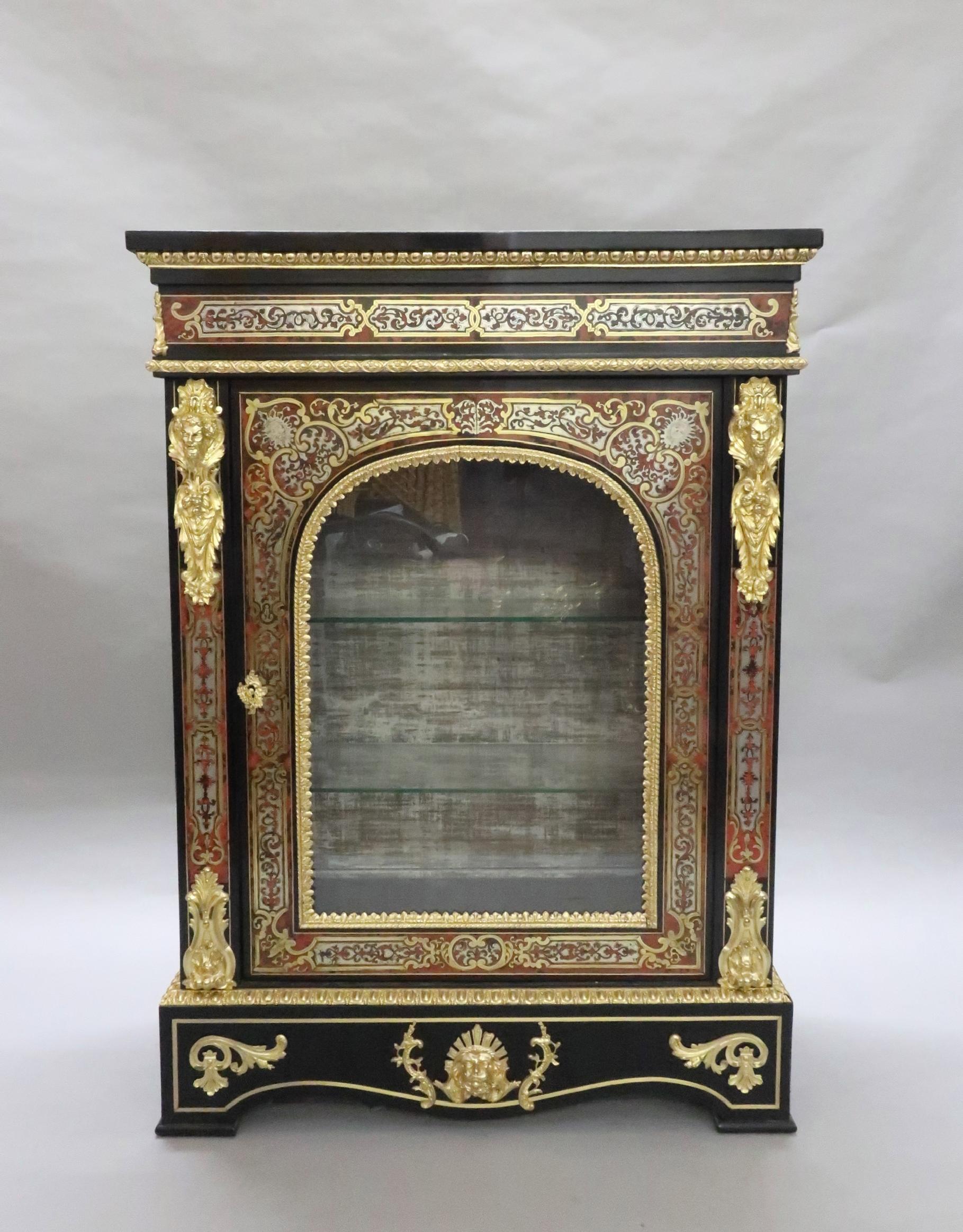 An exceptional pair of English Victorian ebony and ebonized boulle side or display cabinets with red tortoiseshell, pewter and brass inlay in the French Louis XIV style.

The cabinets have scrolling foliate inlaid design to the front with single