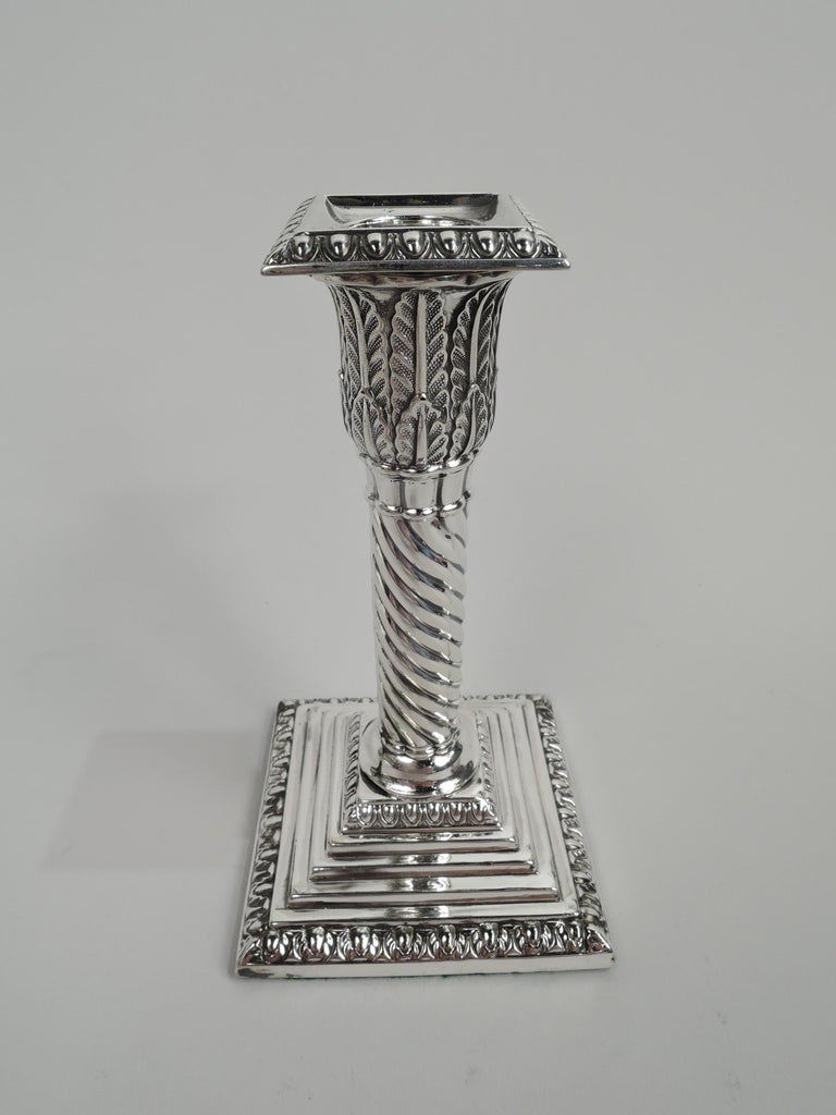 Pair of Victorian Classical sterling silver candlesticks. Made by Hawksworth, Eyre & Co., Ltd in Sheffield in 1881. Twisted fluted shaft on stepped and square base. Socket applied with imbricated leaves; square and detachable bobeche. Egg-and-dart