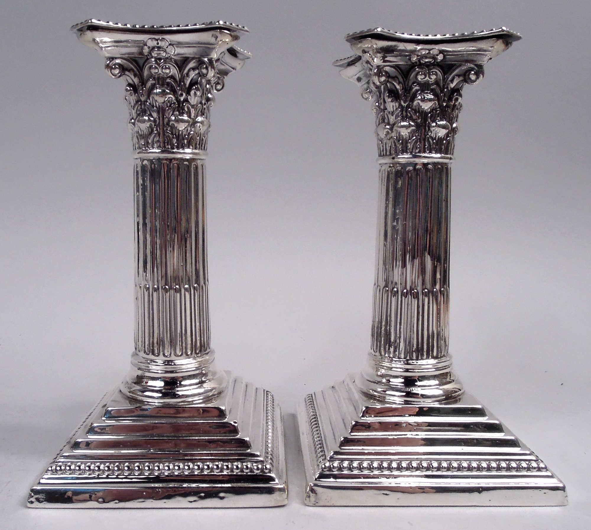 Paire de chandeliers en argent sterling de style néoclassique victorien anglais, 1893. Chaque : Colonne traditionnelle avec arbre à cannelures sur pied carré à gradins. Chapiteau corinthien composite aux côtés concaves et à la bobèche amovible.