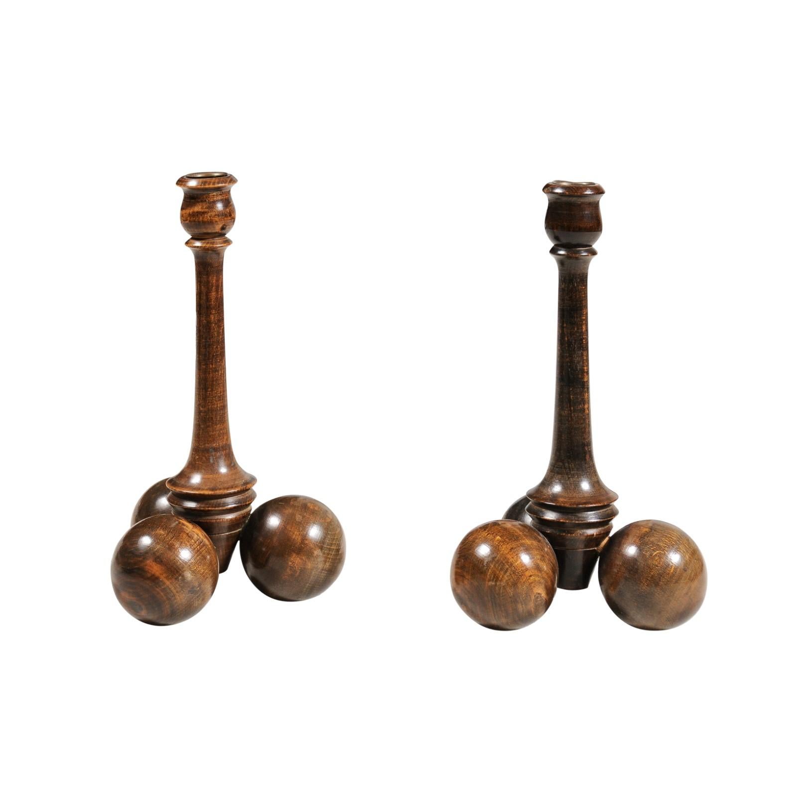 A pair of Victorian period wooden candlesticks from the late 19th century, with tubular shaped bobèches and tripartite spherical bases. Created in England during the later years of Queen Victoria's reign in the 19th century, each of this whimsical