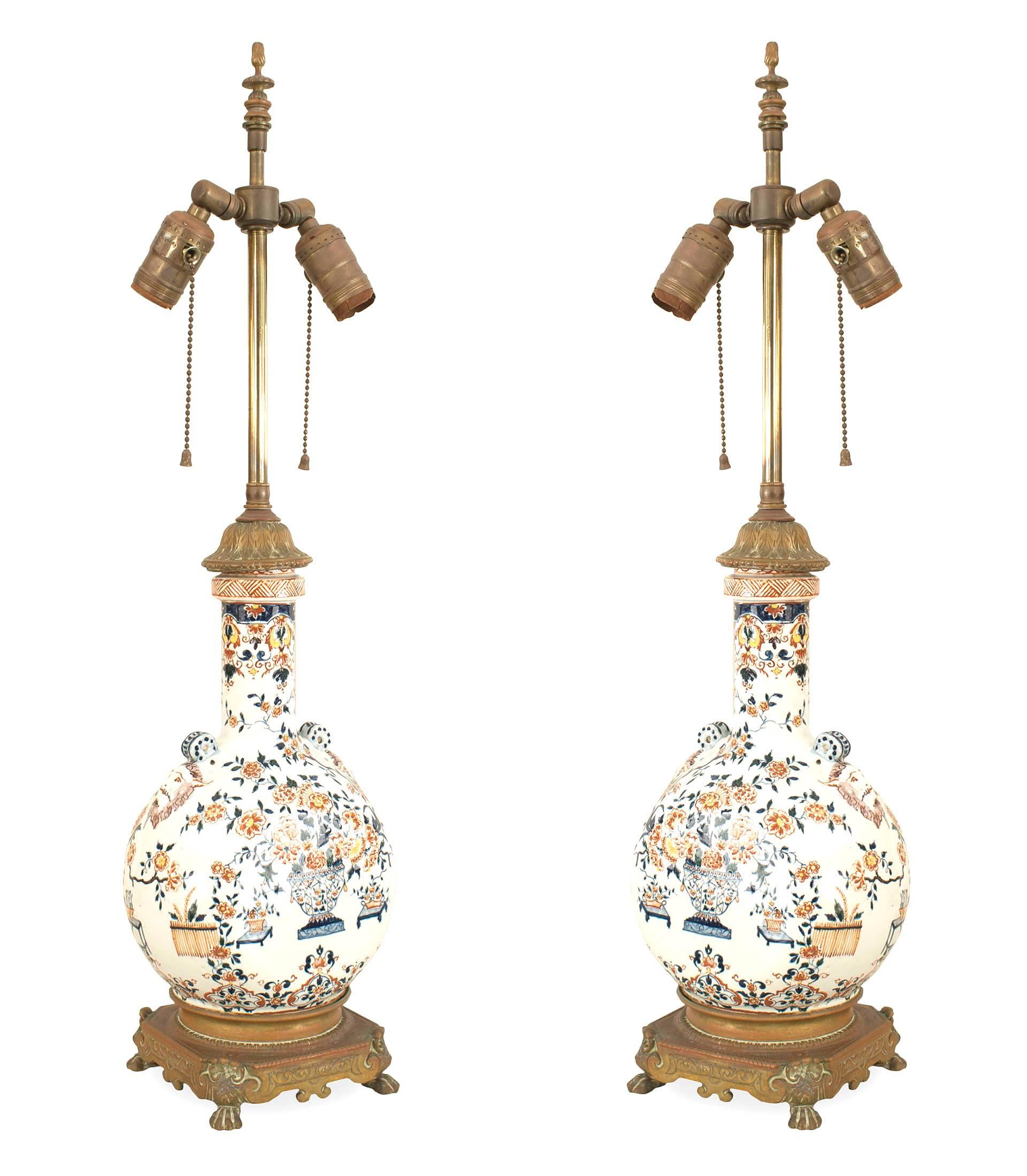 Pair of English Victorian Pilgrim shaped white porcelain table lamps with red & blue floral decoration and satyr heads having a bronze square base with claw feet (PRICED AS Pair)
