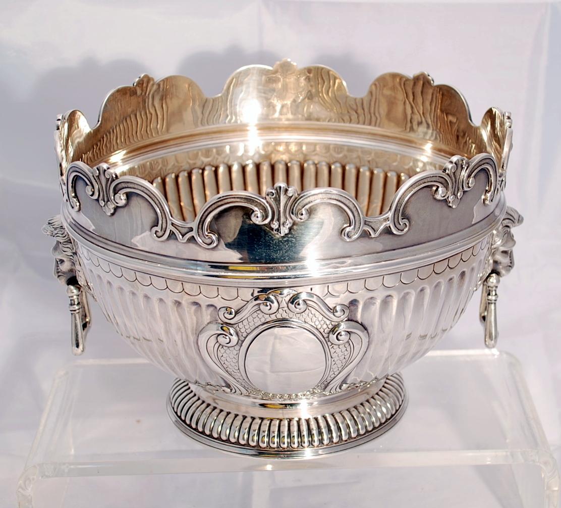 Pair of Victorian sterling silver Monteith bowls. One marked with Walter & John Barnard, London, 1895; One marked with Goldsmiths & Silversmiths co., 1908. Shaped circular on gadrooned foot with fluted body. The hinged handles with lion's-head and