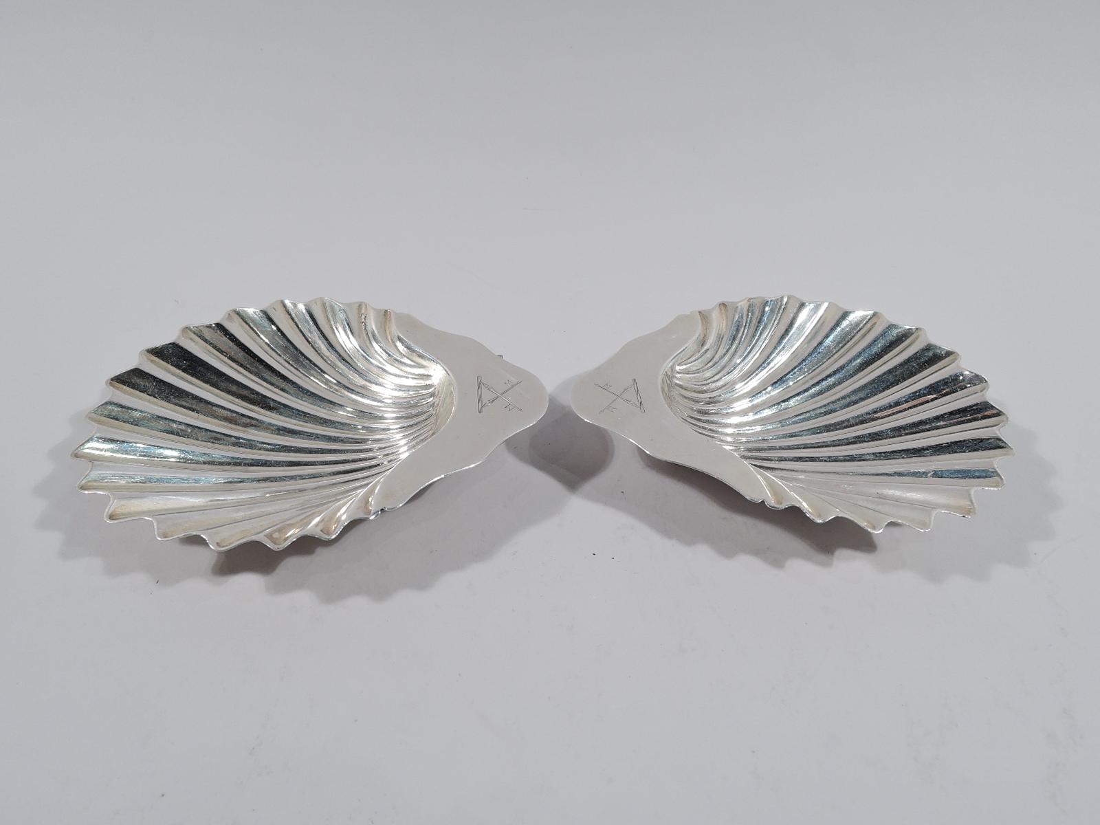 Pair of Victorian sterling silver scallop shells. Made by William Gibson and John Langman in Sheffield in 1885. Each: Crisp and deep flutes and scroll handle with engraved armorial. Rests on 3 conch shells. Fully marked including maker's and