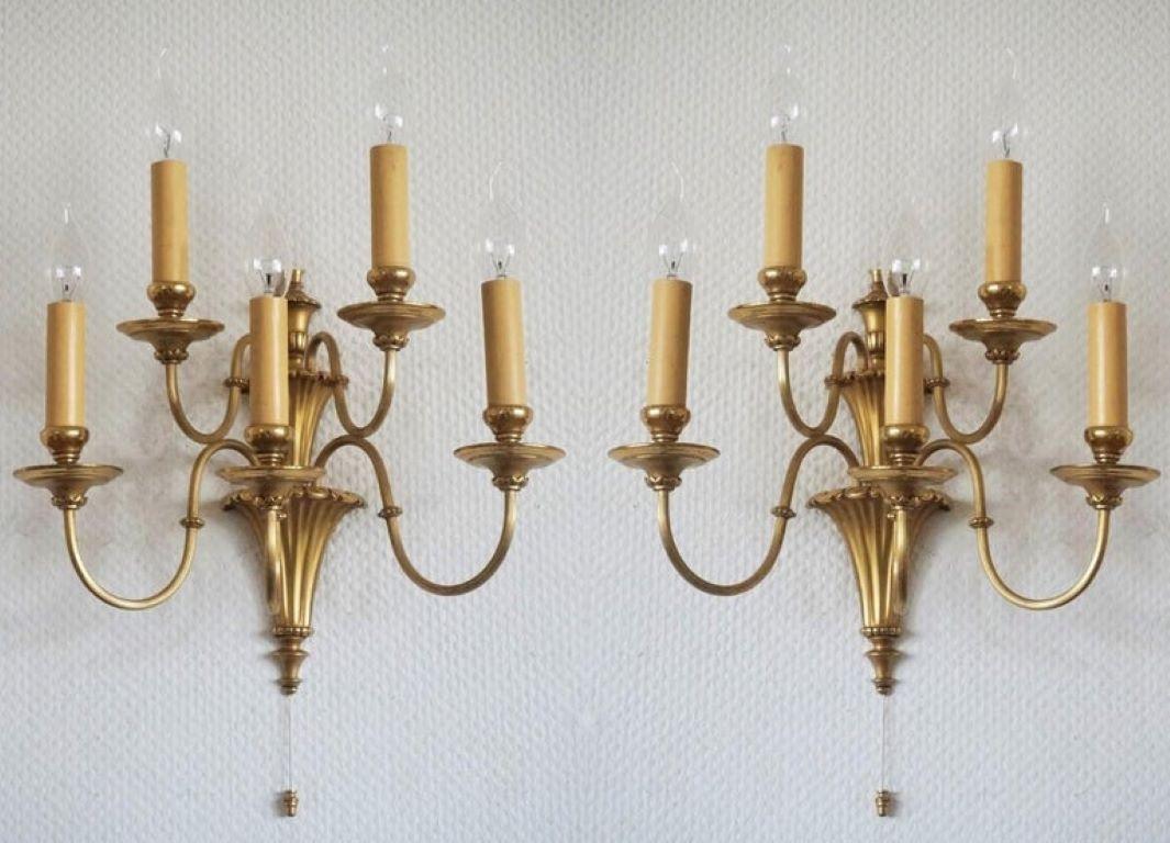 A pair of Victorian style gilt brass wall sconces with five scrolling arms and a fluted conical base, England, early 20th century. The sconces had been electrified with five Edison E14 light sockets with candle covers and pull-down switch. Both