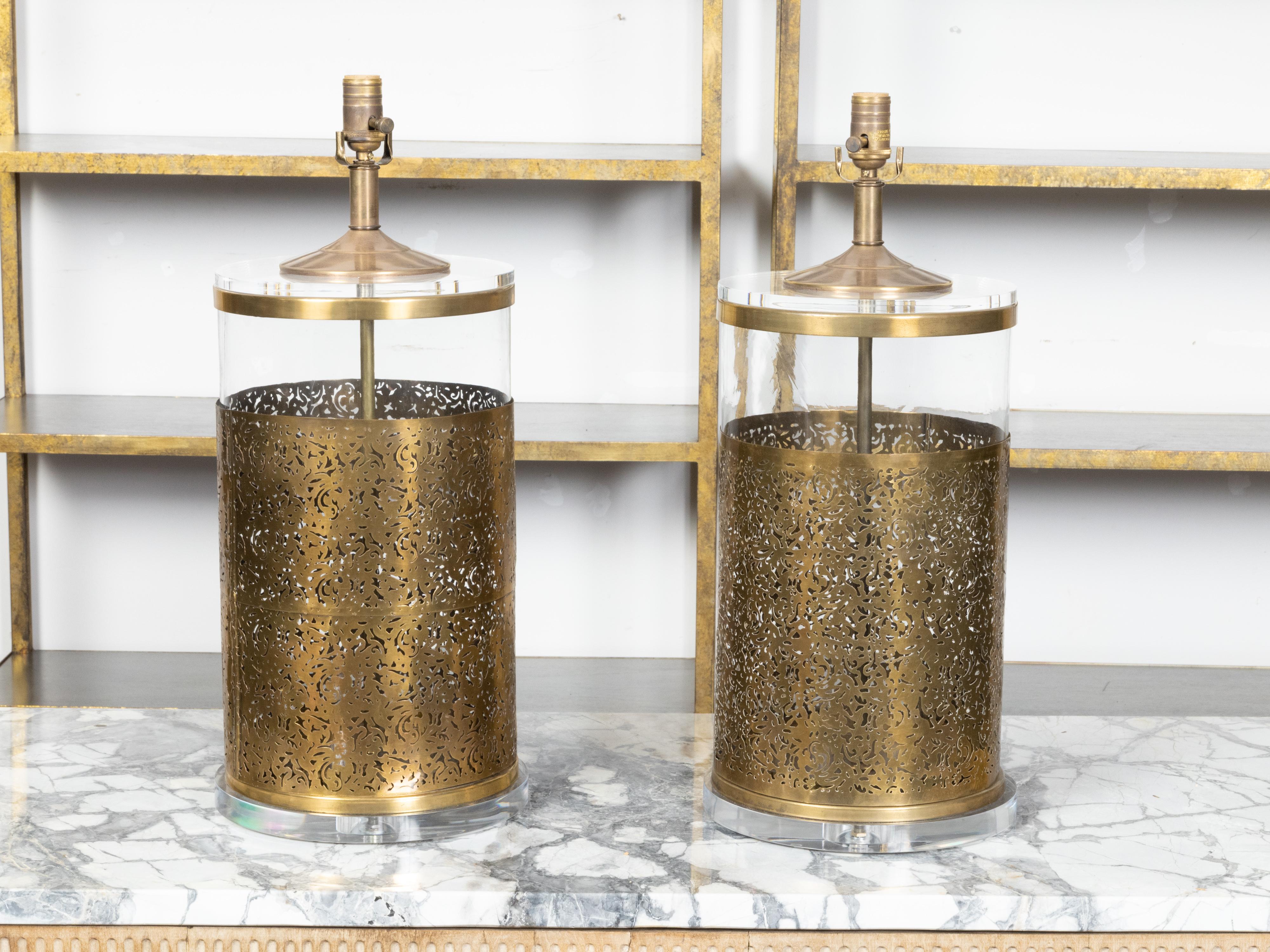 A pair of English vintage brass and glass table lamps from the late 20th century, with openwork motifs, custom made lucite bases and professional rewiring for the US. Created in England during the second half of the 20th century, each of this pair