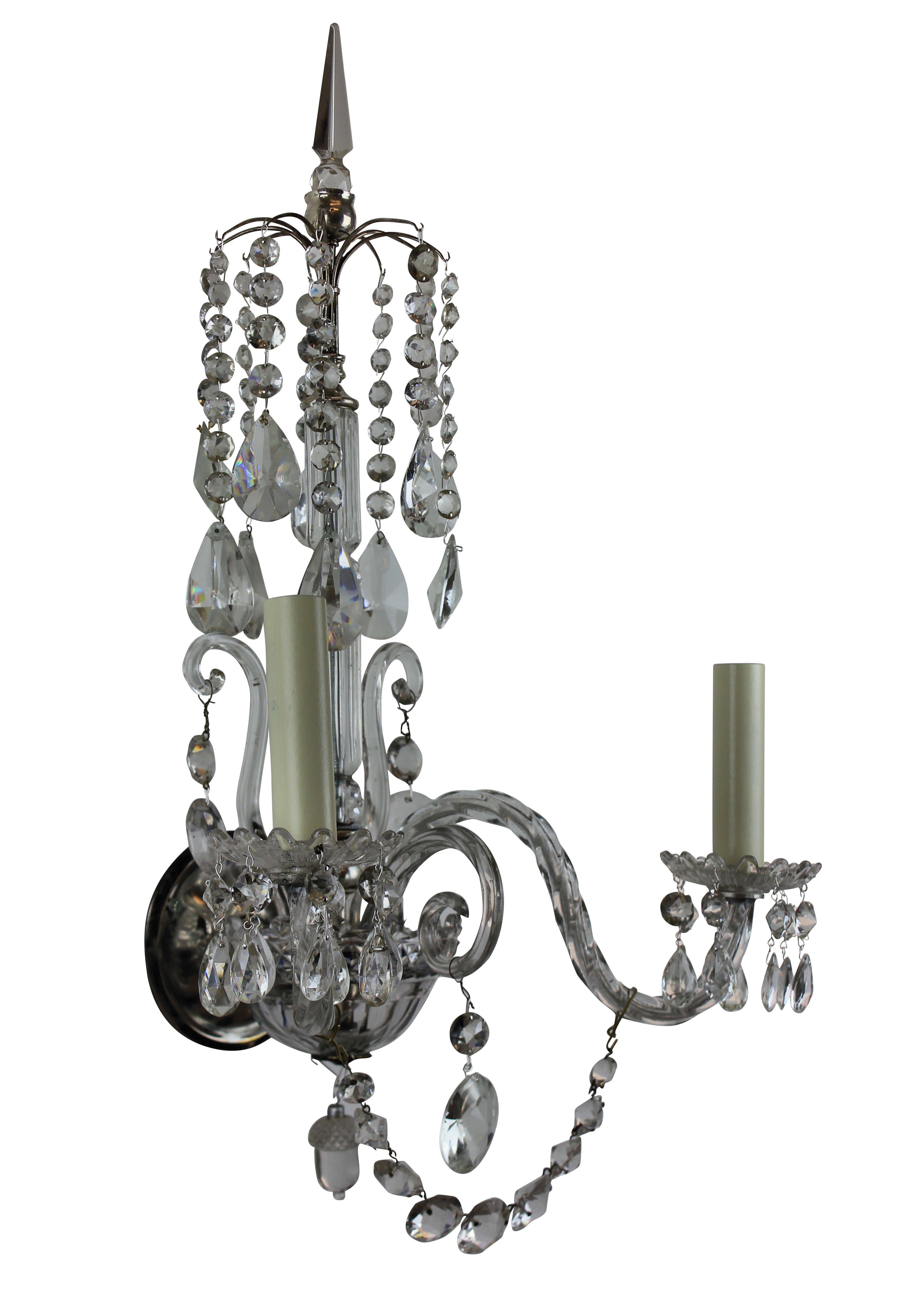 A pair of English cut and moulded glass wall lights, each with two arms. With central spike and canopy and swags. In the Regency style.