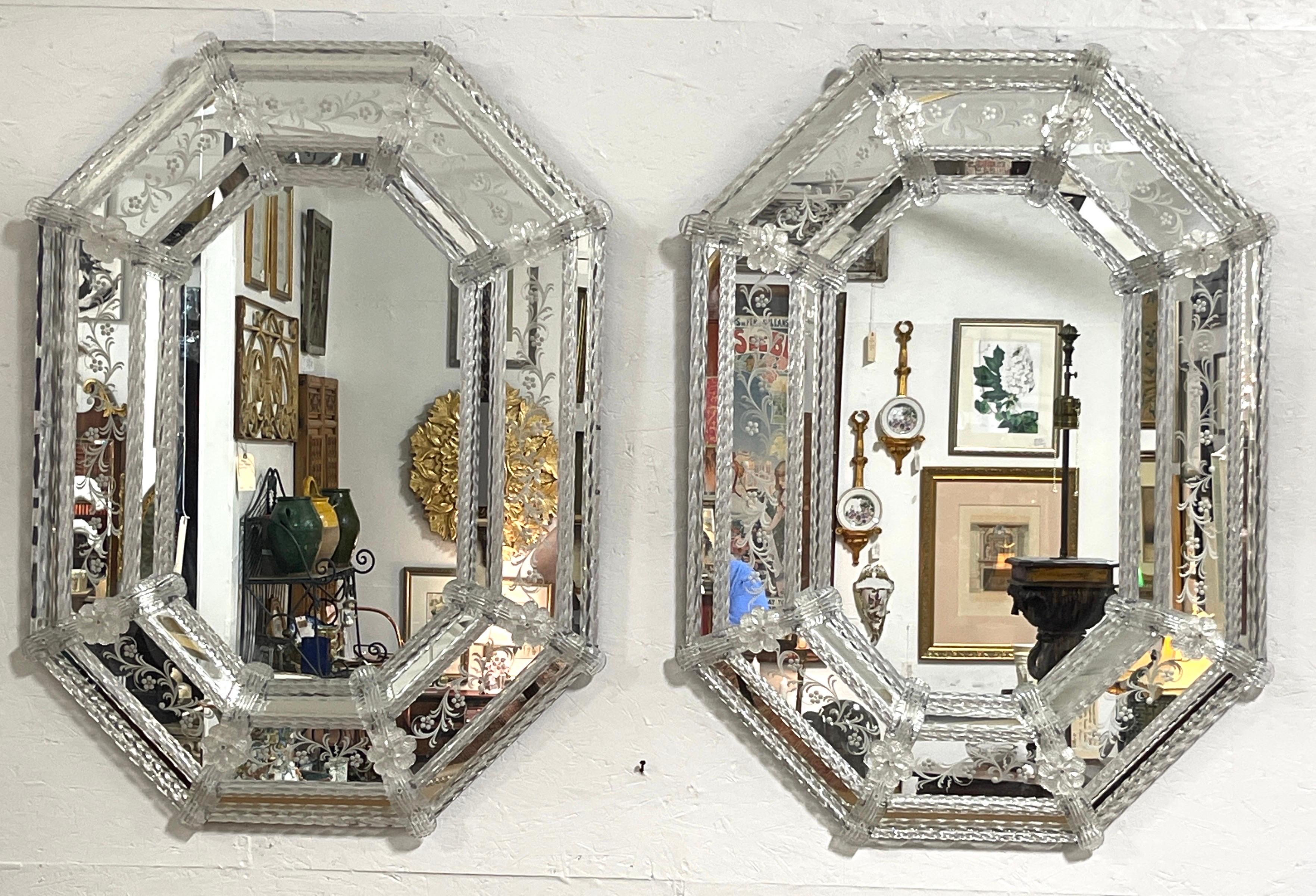 Pair of Engraved Clear Venetian Glass Cushioned Mirrors 
Italy, circa 1950s

A rare opportunity to acquire a pair of vintage Venetian glass mirrors, Each one of cushioned octagonal form with intricate applied Venetian glass flower heads, rope trim,