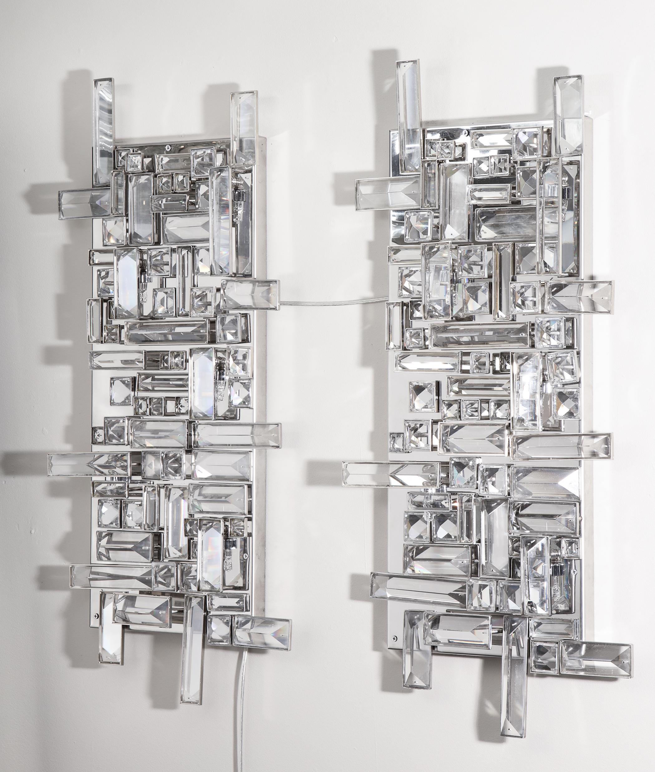 Pair of enormous polished nickel sconces with Austrian baguette crystals. Each crystal is hand-placed to create a unique asymmetrical design. The back plate is 27.5