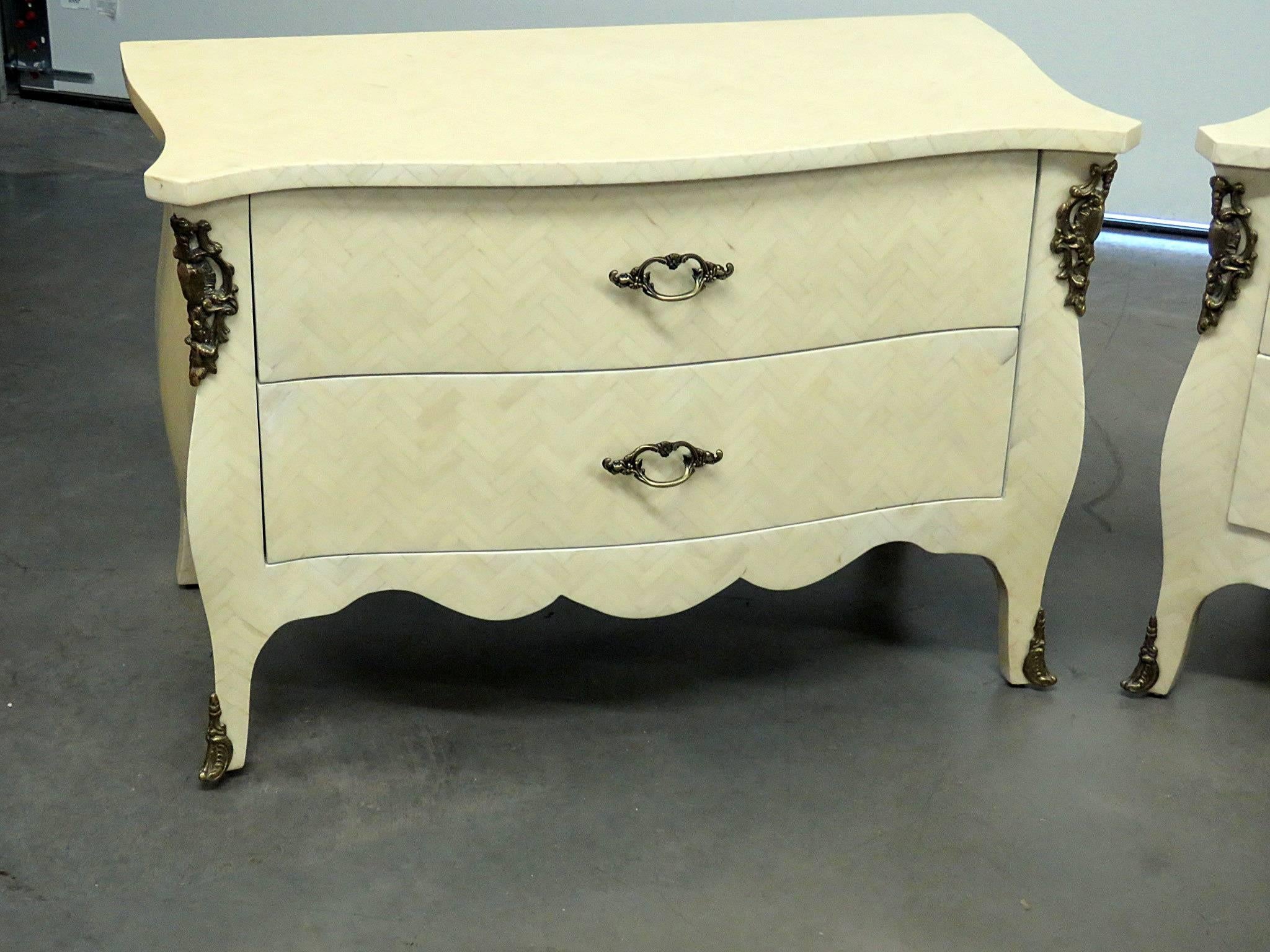 Pair of Enrique Garcia two-drawer commodes with faux bone veneer and bronze accents.