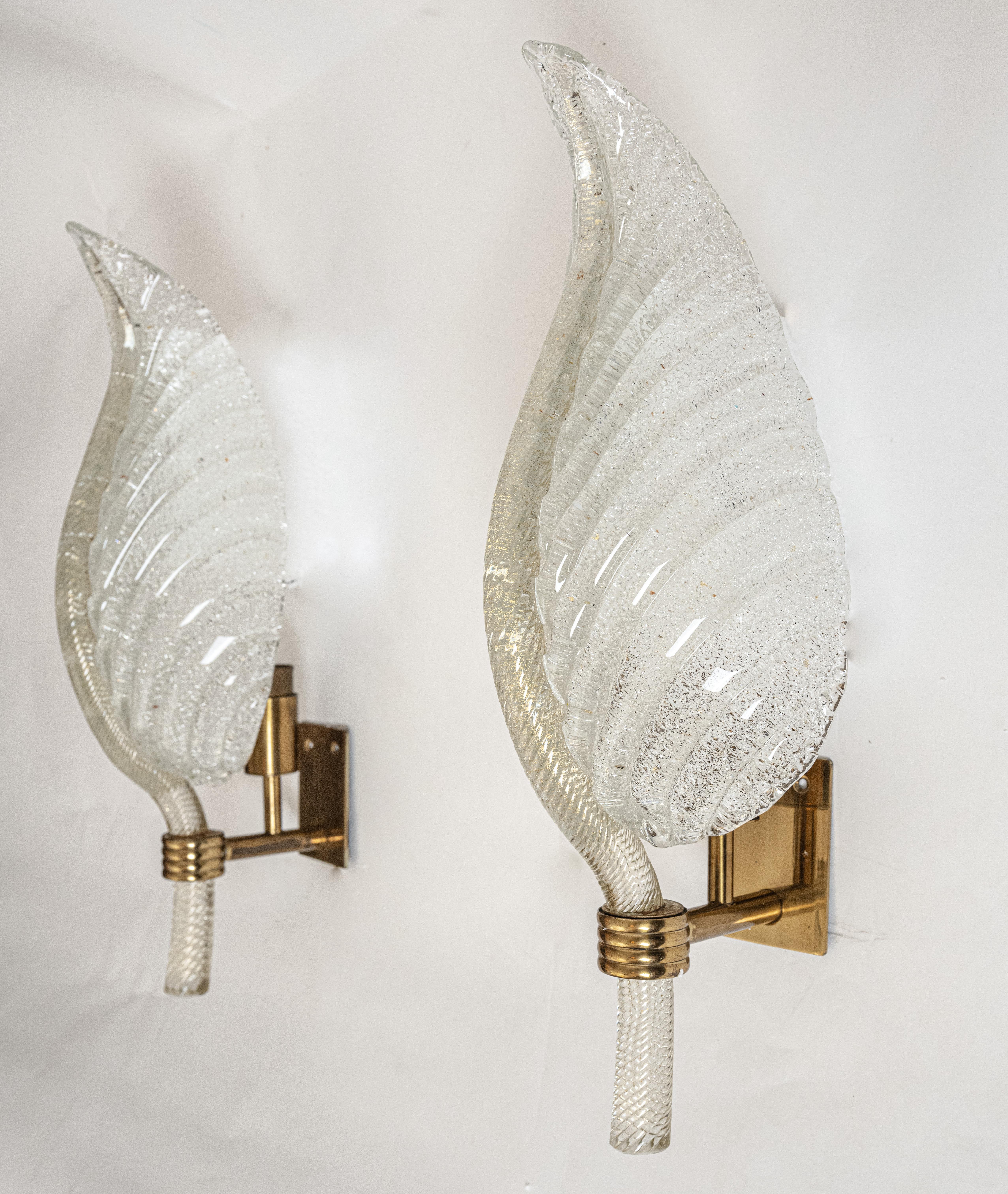 Pair of Mid Century sconces by Italian artist Ercole Barovier (1889-1974) for Barovier & Toso. With a glass shade formed into a leaf shape and having a brass backing. The oversized leaf has a spine with  gold fleck and a the ribbing features a