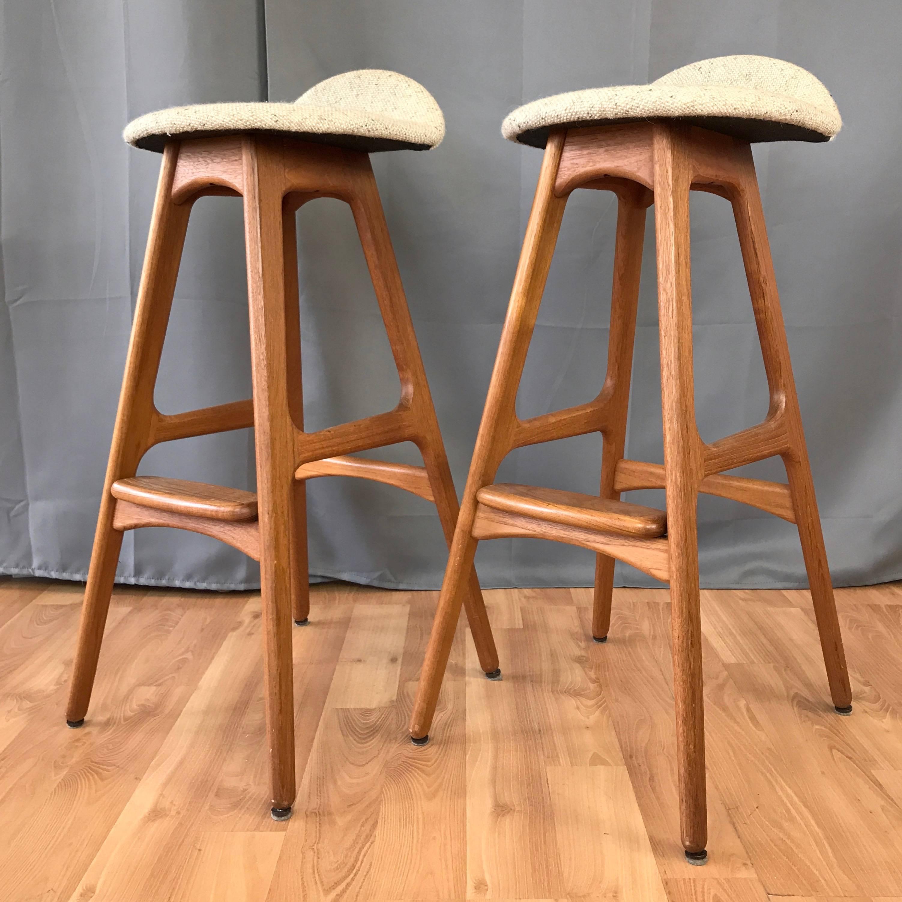 A pair of model OD-61 teak bar stools by Erik Buch for Oddense Maskinsnedkeri. 

Iconic Danish modern design with architectural lines in smoothly sculpted solid teak. Sleek seat retains its original flecked oatmeal heavy weight wool custom