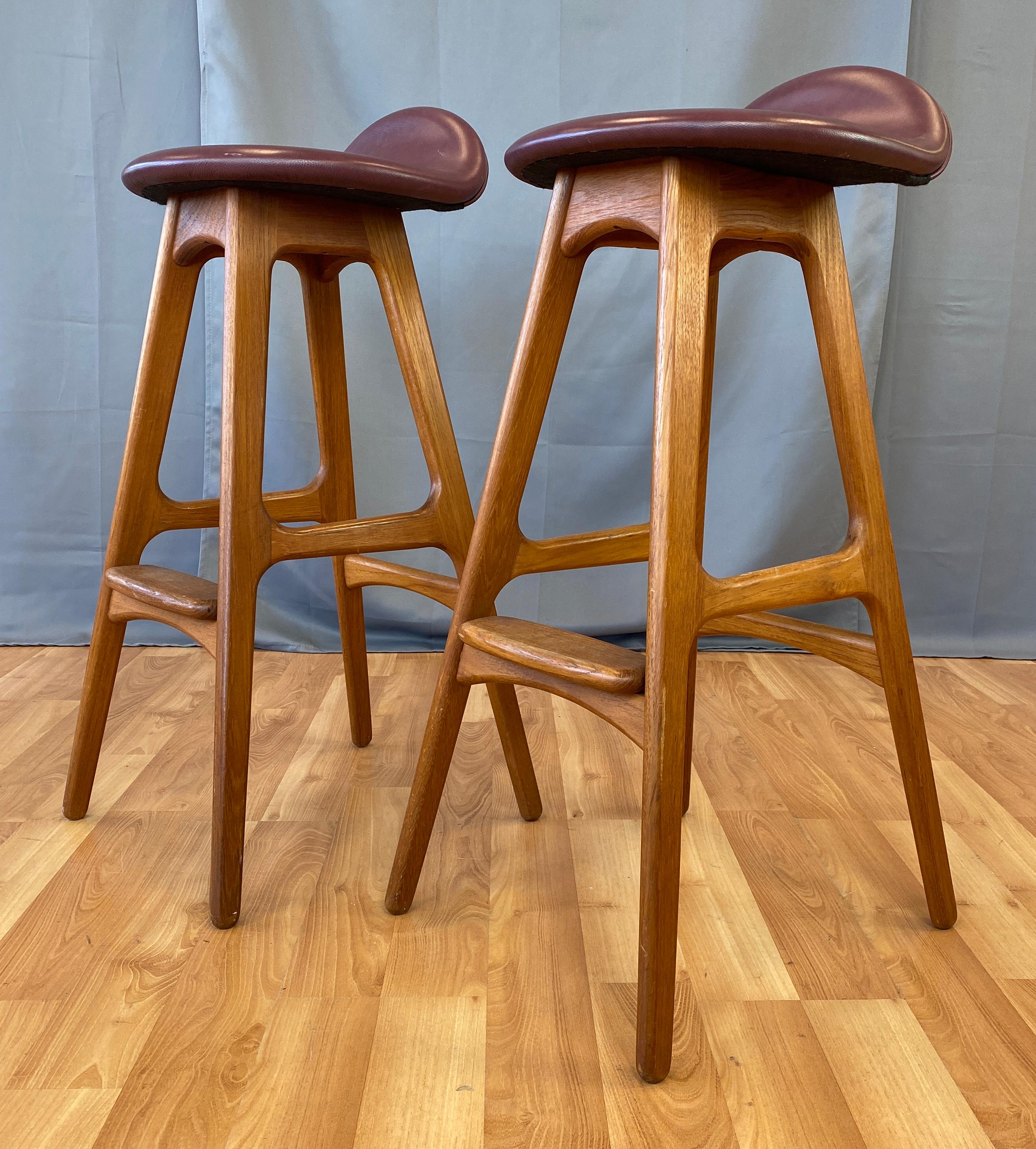 A pair of model OD-61 teak bar stools by Erik Buch for Oddense Maskinsnedkeri. 

Iconic Danish modern design with architectural lines in smoothly sculpted solid teak. Sleek seat retains Burgundy leather custom upholstery.