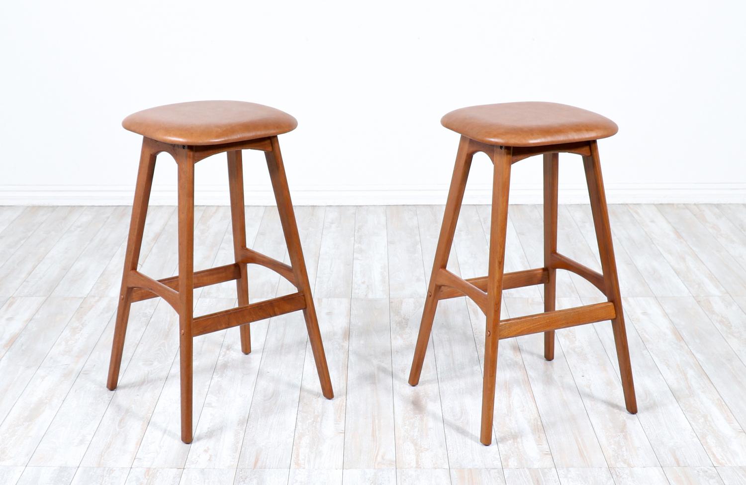Pair of Erik Buch Teak & Tan leather bar stools.

________________________________________

Transforming a piece of Mid-Century Modern furniture is like bringing history back to life, and we take this journey with passion and precision. With over 17