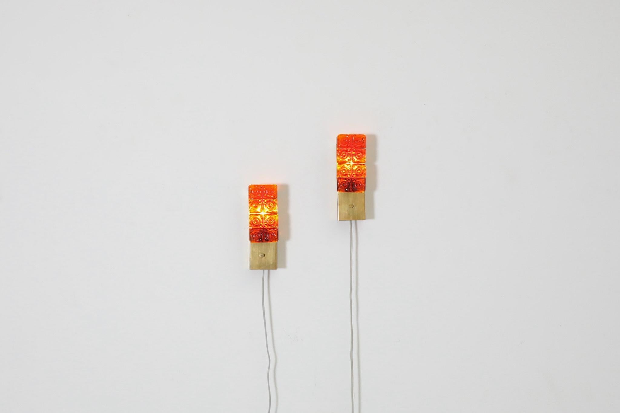 Stunning pair of Erik Höglund inspired, Mid-Century molded orange glass and brass sconces by Austrian lighting manufacturer, HAGS. In original condition with visible wear consistent with their age and use. Set price.