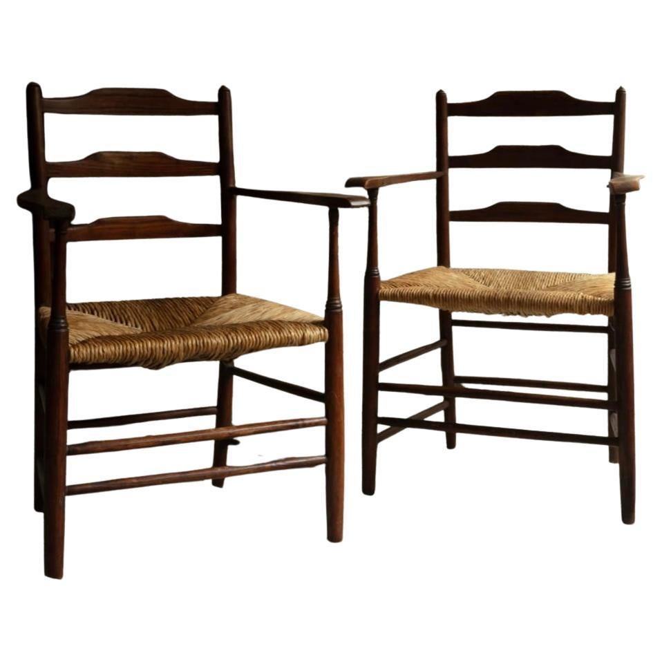 Pair of Ernest Gimson “Clissett” low ladderback armchairs by Edward Gardiner.