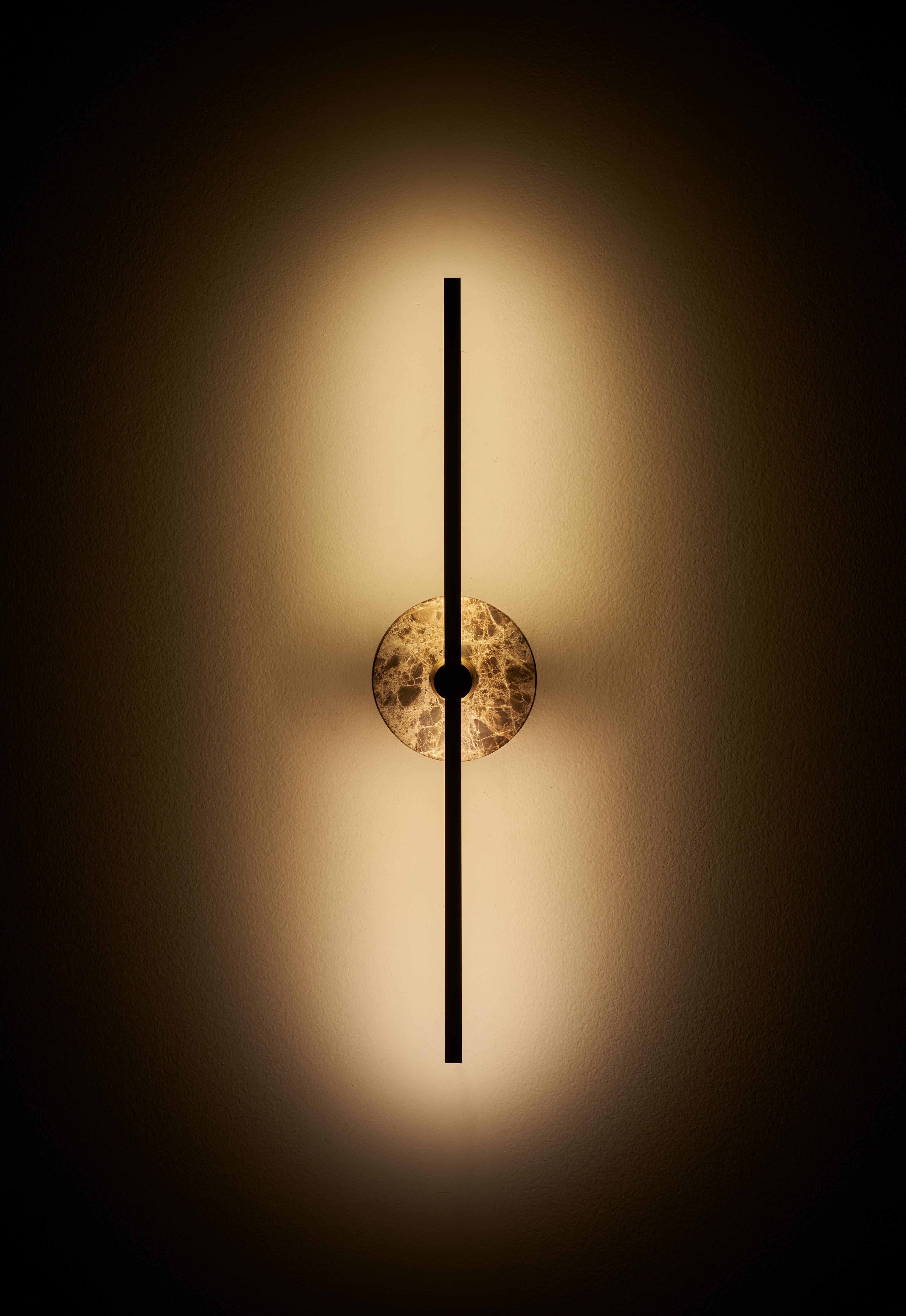 The Stick wall sconce is a contemporary lighting fixture that features a minimalist design with thin brass profiles and advanced LED technology. It emits a warm and diffused light that adds a cozy and inviting atmosphere to any room.

The brown