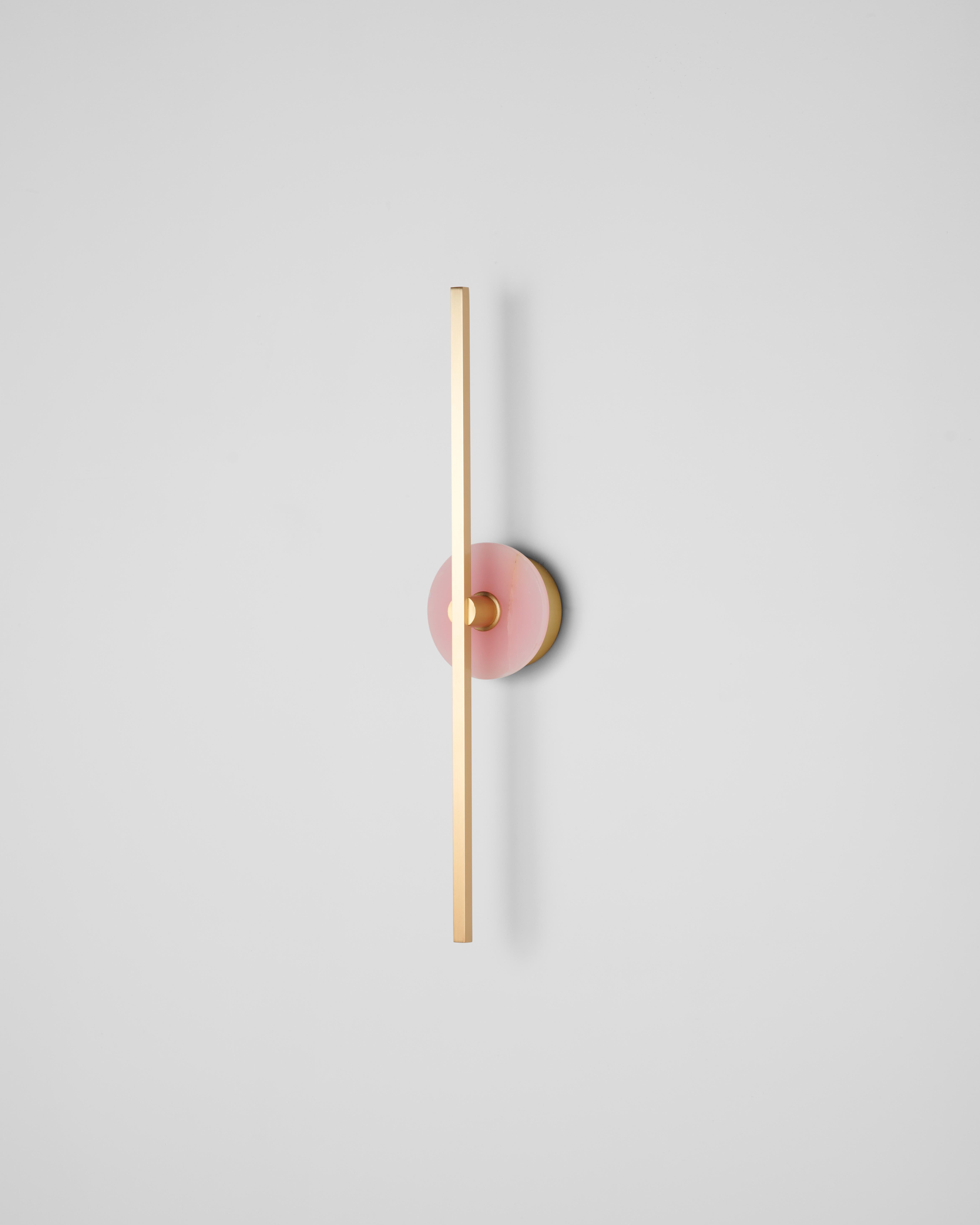 El aplique de pared Stick es un accesorio de iluminación contemporáneo que presenta un diseño minimalista con finos perfiles de latón y avanzada tecnología LED. Emite una luz cálida y difusa que añade un ambiente acogedor y acogedor a cualquier
