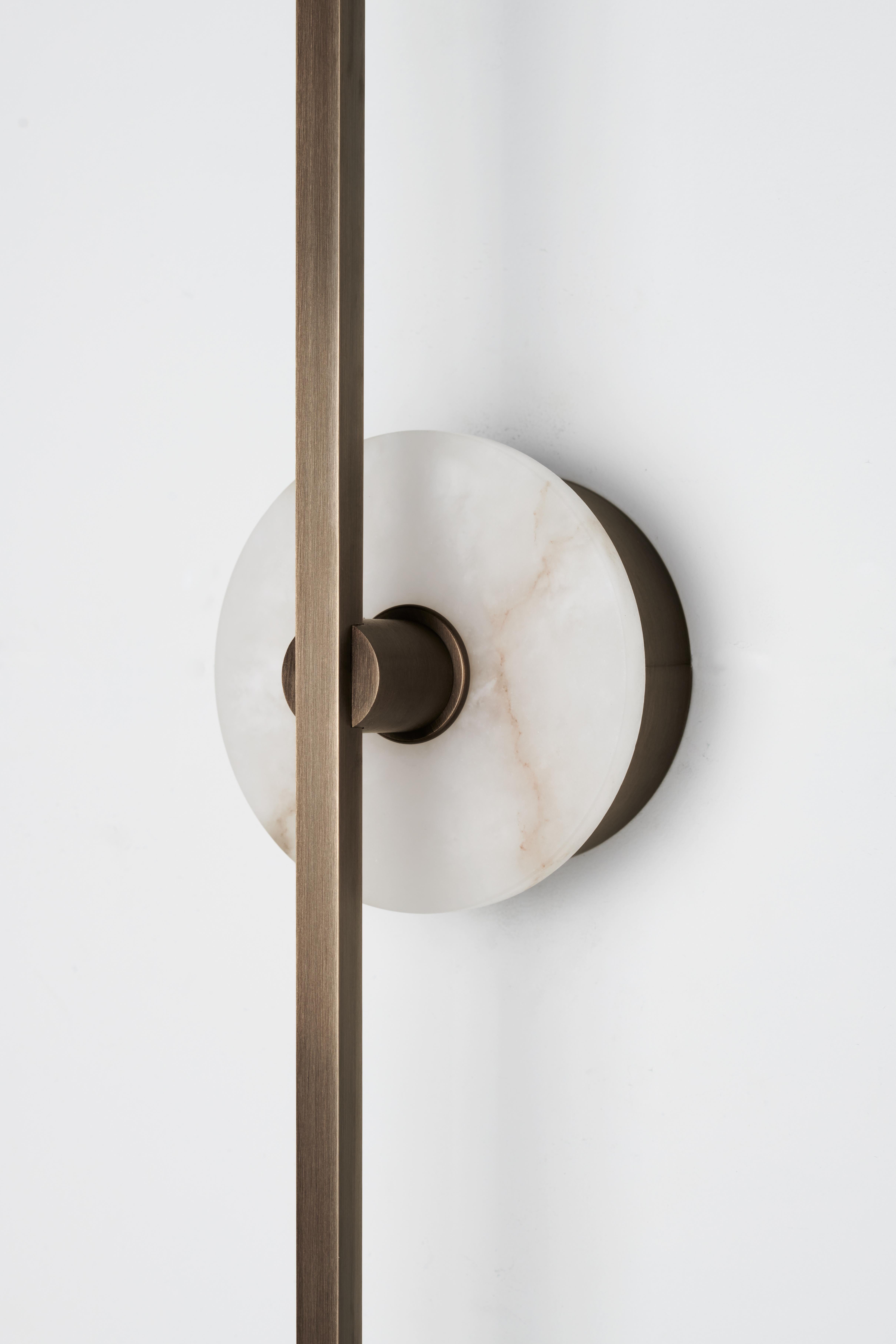 The Stick wall sconce is a contemporary lighting fixture that features a minimalist design with thin brass profiles and advanced LED technology. It emits a warm and diffused light that adds a cozy and inviting atmosphere to any room.

The Alabaster