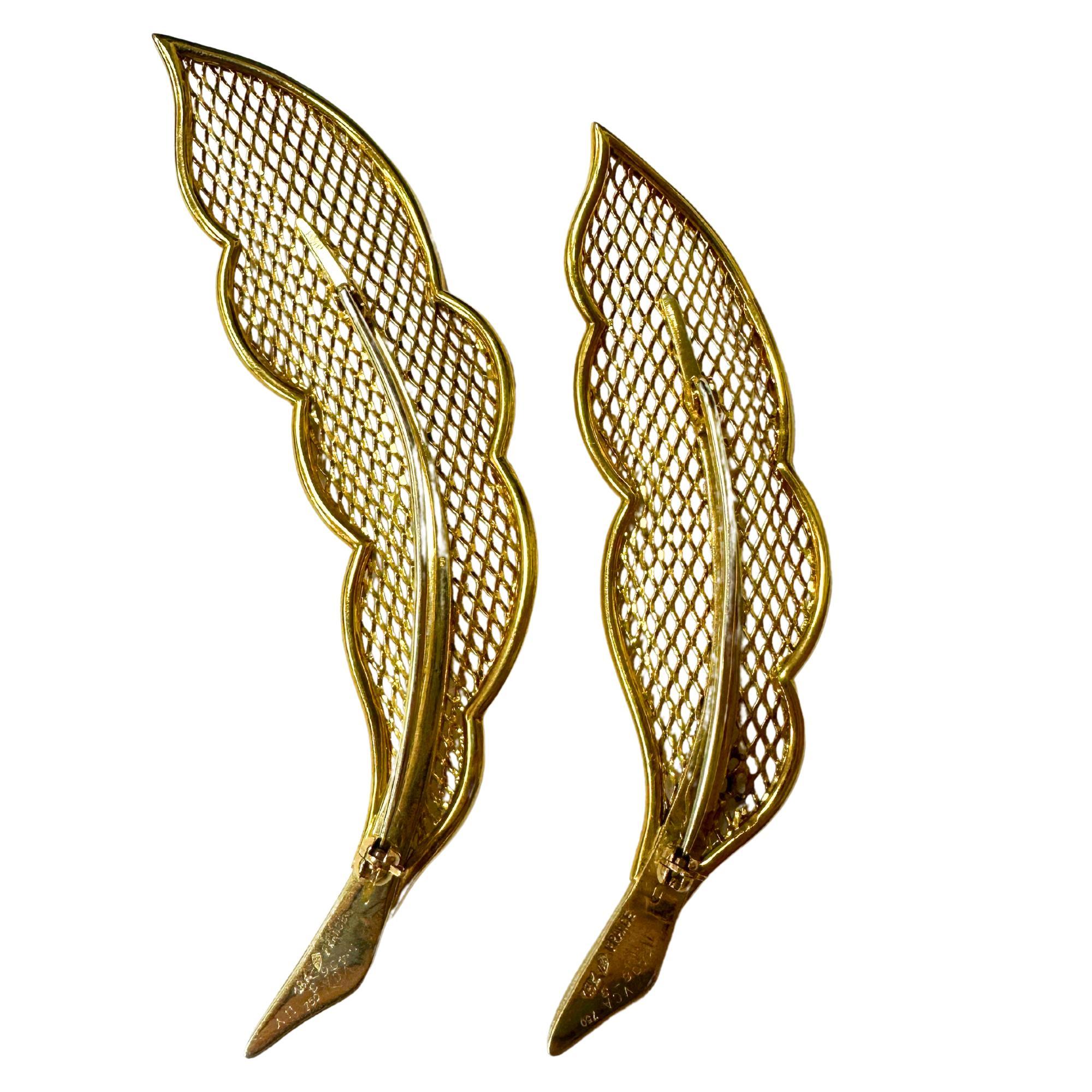 Experience the luxury and elegance of this Pair of 18k Van Cleef and Arpels Feather Brooches. Crafted from 18k yellow gold with intricate markings of 