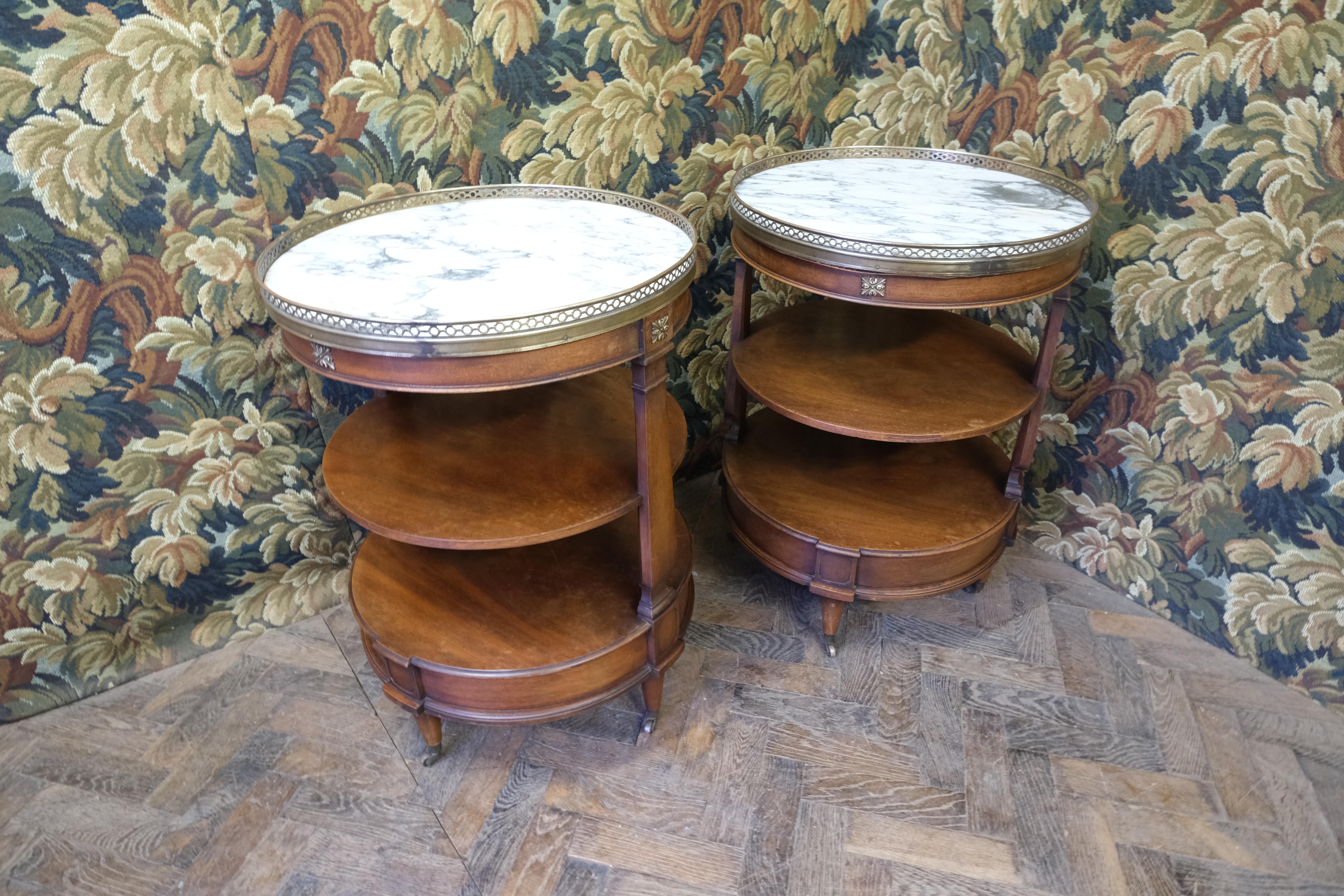 Hutton-Clarke Antiques is delighted to present an exquisite pair of étagère tables, crafted in an elegant French manner by the renowned W. M. Barclay from the United States. These tables are masterfully constructed from rich mahogany, featuring tops