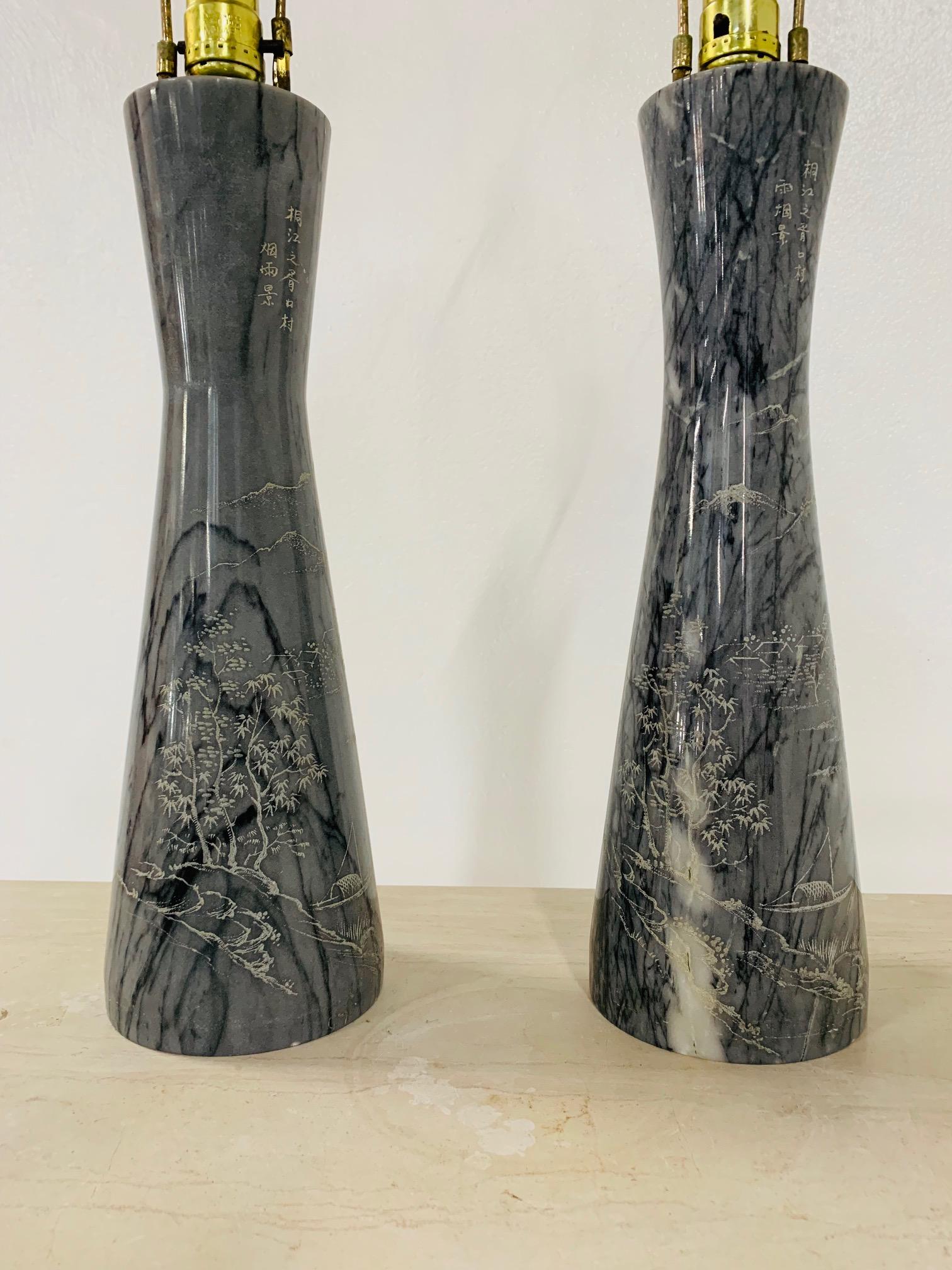 Pair of etched Asian Themed marble lamps. The lamps have an etched, outdoor Asian scenery theme.
Measures: 31.5 height (top of finial). Base: 5