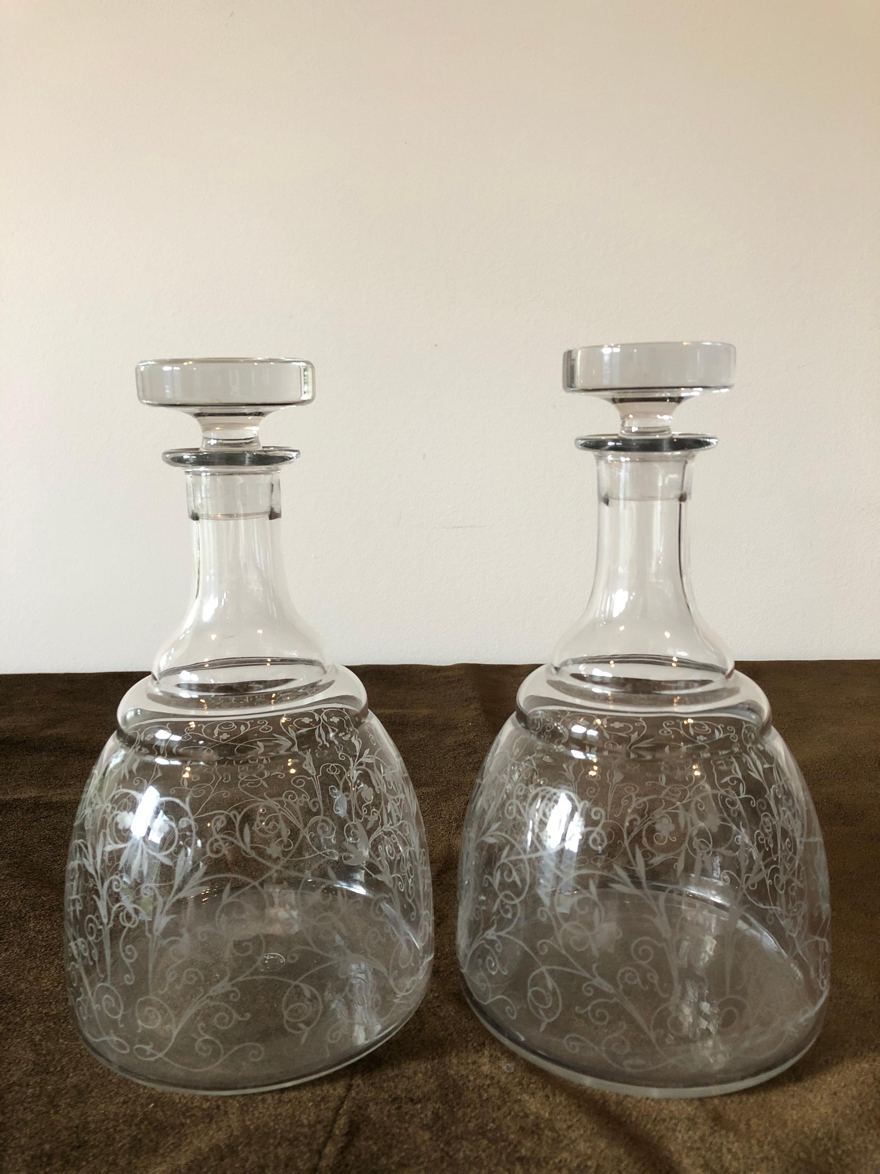 A beautiful matched pair of crystal Baccarat decanters. Etched with vine and leaf motif and complete with stoppers.